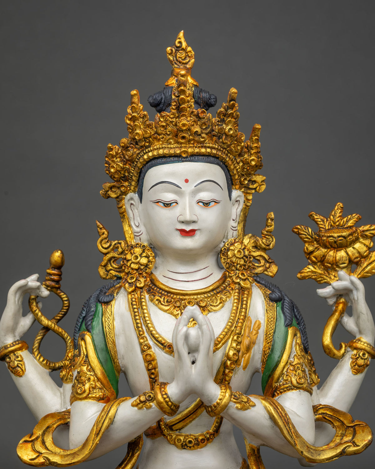 Close-up of Chenrezig’s serene painted face, gold jeweled crown and ornate necklace