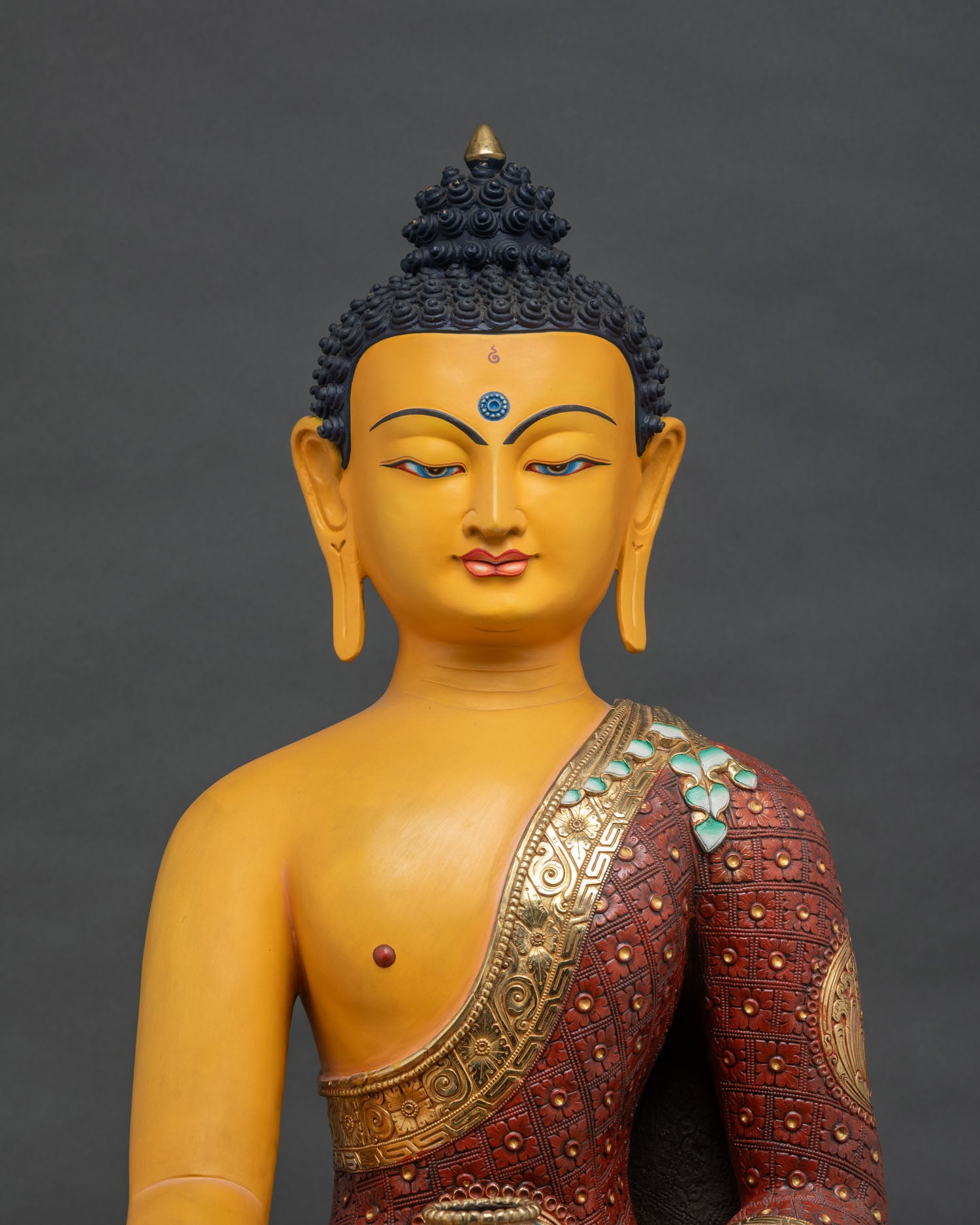 Close-up of colorful Shakyamuni Buddha statue, gold gilding and hand-painted robe detail