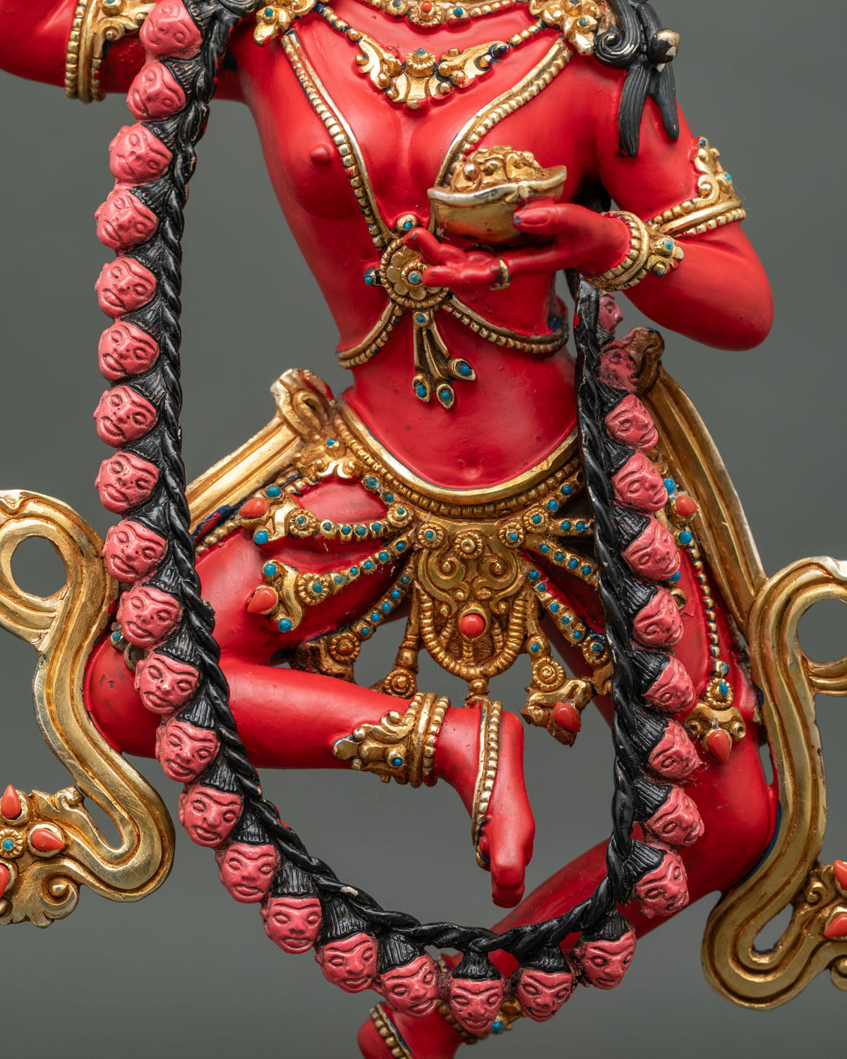 Close-up of Dorje Phagmo statue holding a kapala at her heart with a garland of heads and jeweled belt
