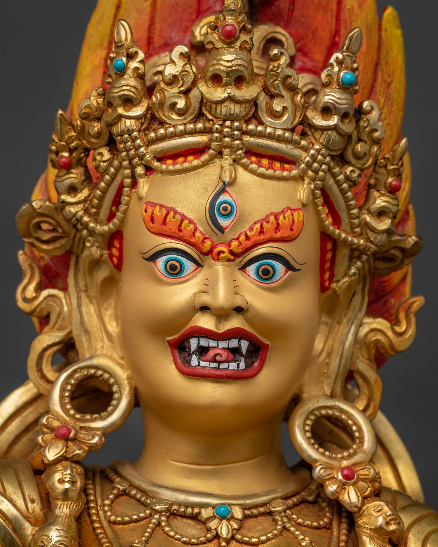 Close-up of Dorje Phagmo Vajravarahi gold-painted face with jeweled crown and fierce expression