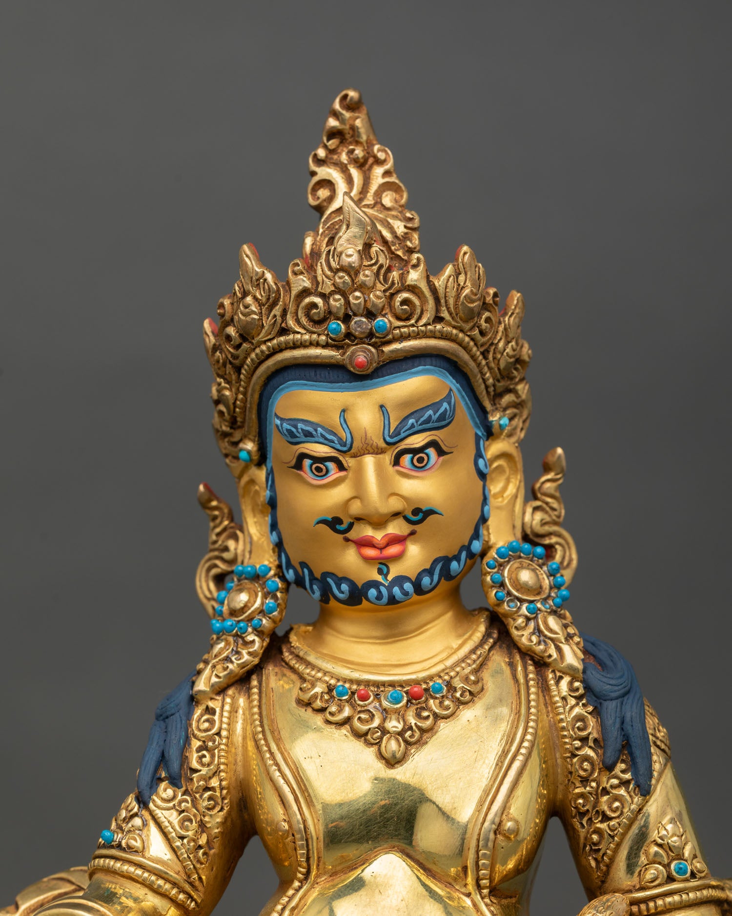 Close up of Dzambhala face with ornate jeweled crown semi precious stone inlays and intricate hand painted details