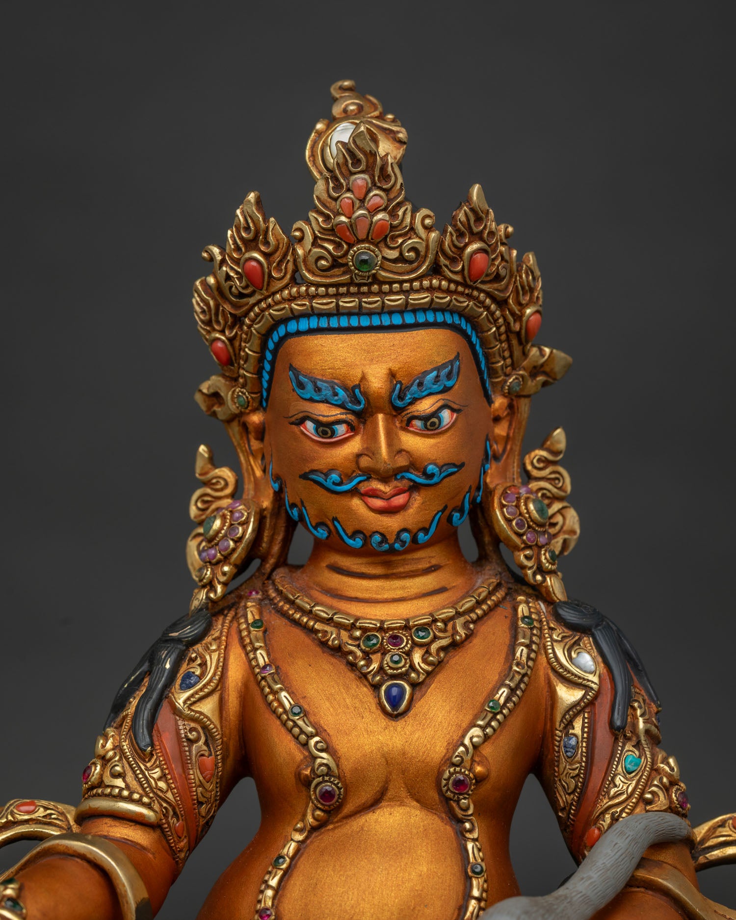 Close up of Dzambhala Statue showing intricate gold-gilded copper detailing