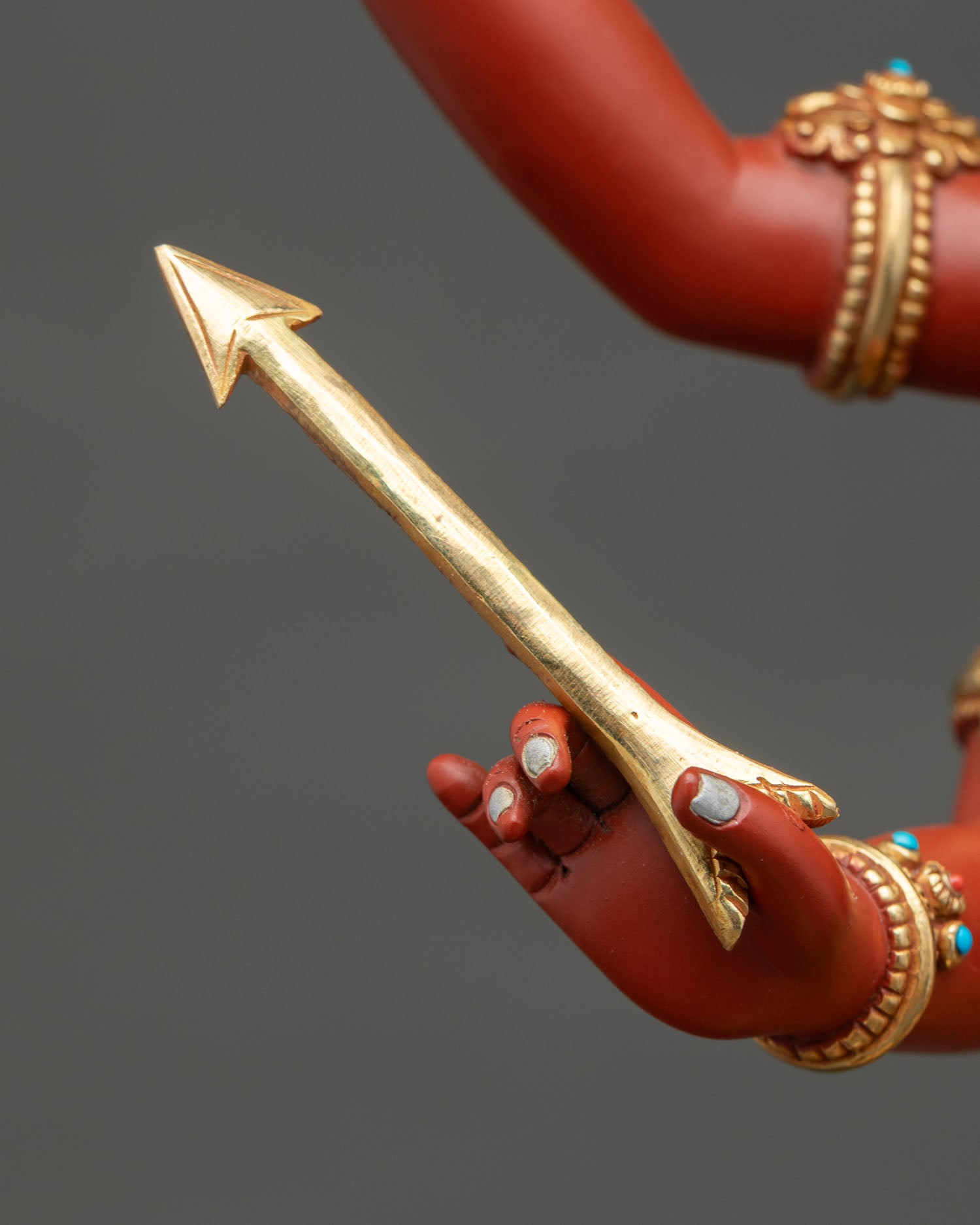 Close-up of gold arrow held by Four-Armed Maha Manjushri statue
