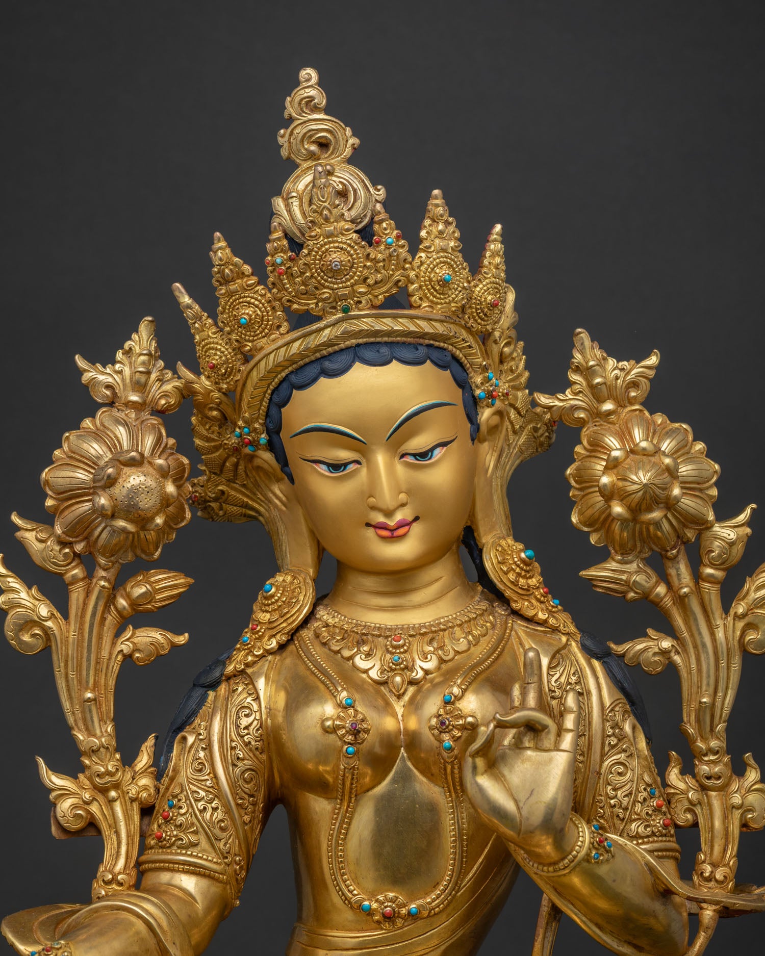 Close-up of gold-gilded Green Tara statue featuring hand-set turquoise and coral gemstones