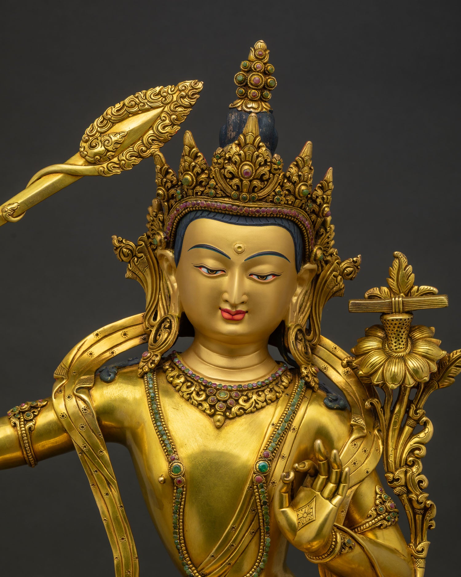 Close-up of gold-gilded Jetsun Jampelyang statue with flaming sword