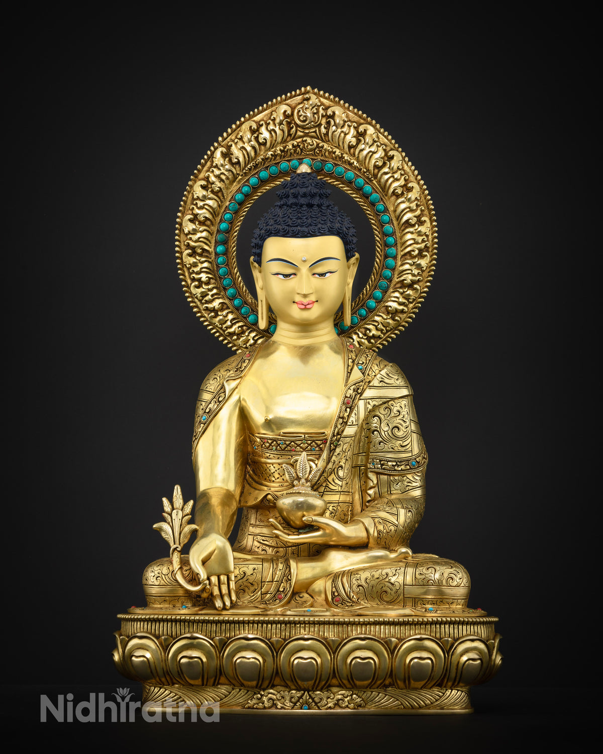 Close up of gold gilded Medicine Buddha statue with turquoise and coral stones, Nepal