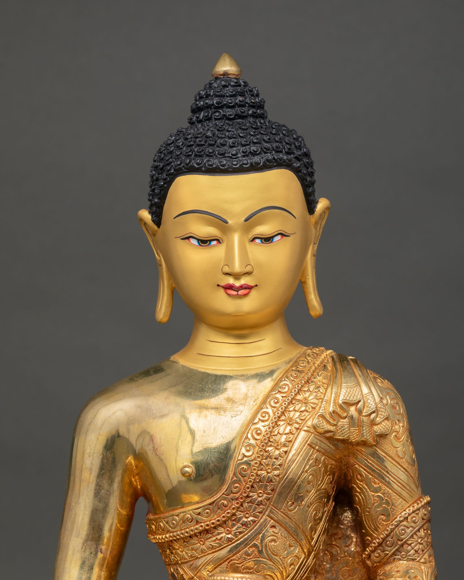 Close-up of the gold-painted face and the serene expression of the Amitabha Buddha statue with intricate detailing