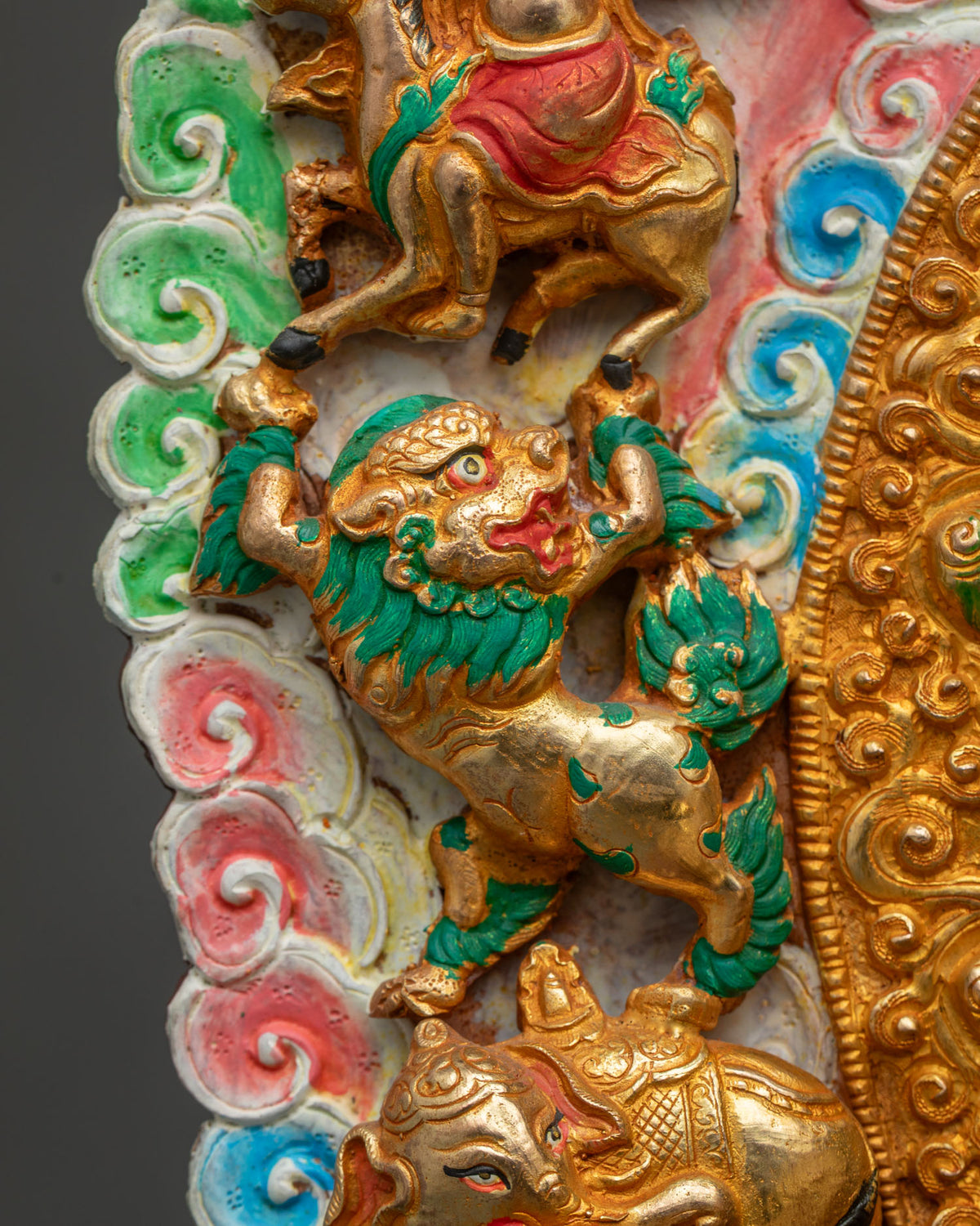 Close-up of green-maned guardian lion carved in gold on Shakyamuni Buddha statue halo