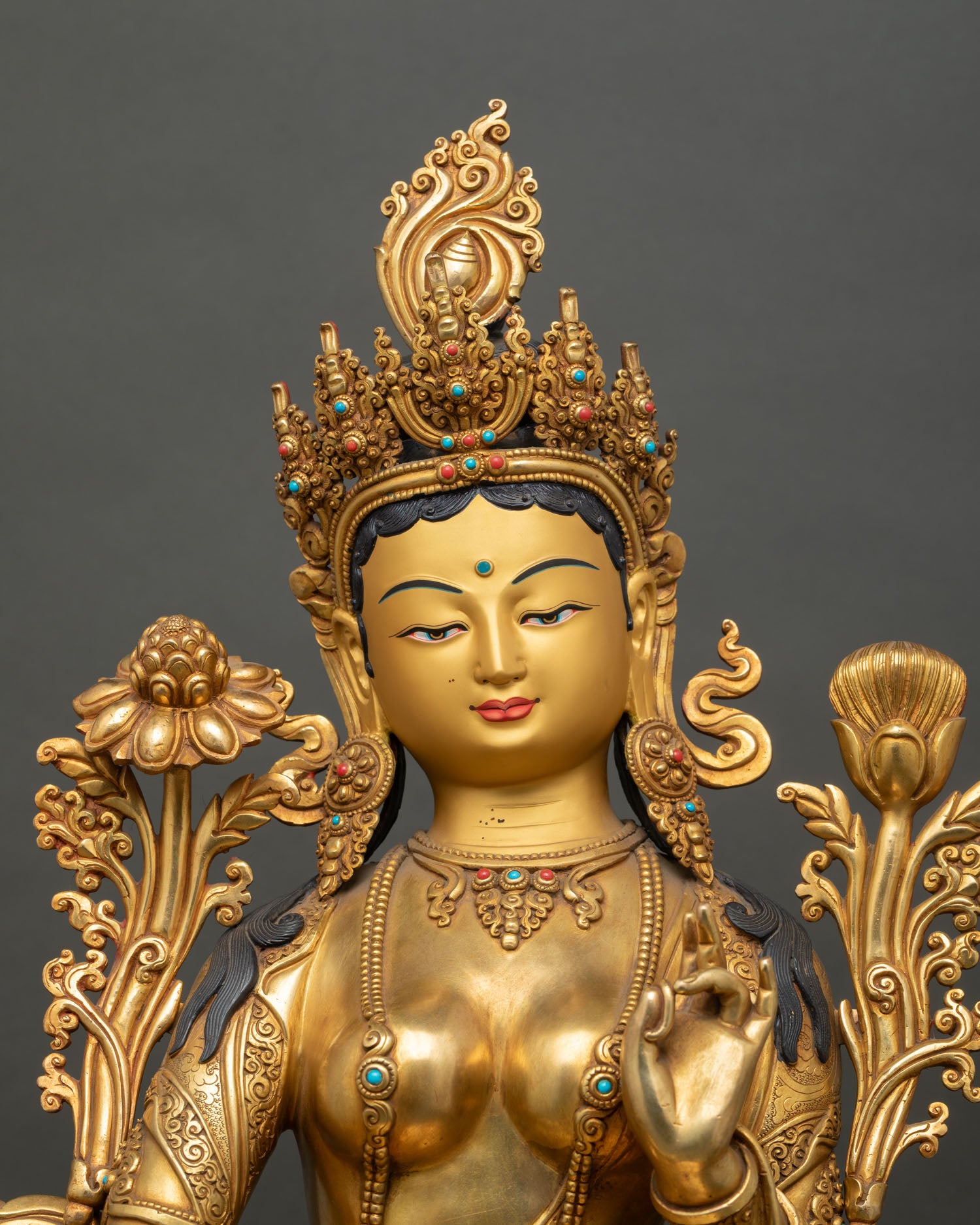 Close-up of Green Tara Buddhist statue with gold fire-gilded details and sacred ornaments