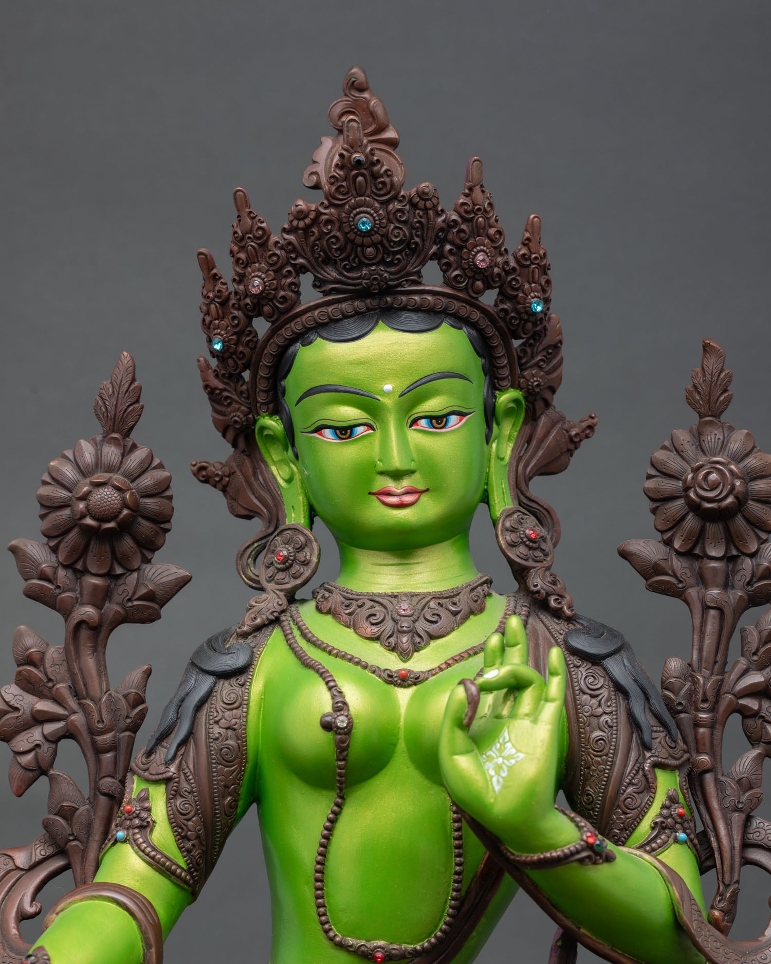 close up of green tara buddhist statue with hand-painted crown and gemstone accents