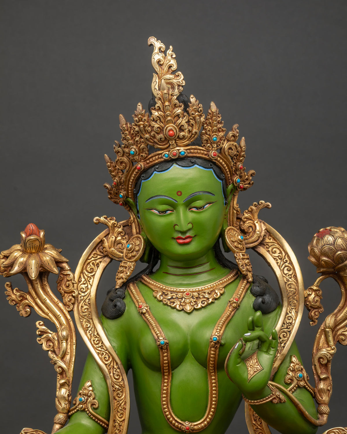 Close-up of Green Tara copper statue seated in Lalitasana with jewel crown and gold gilding
