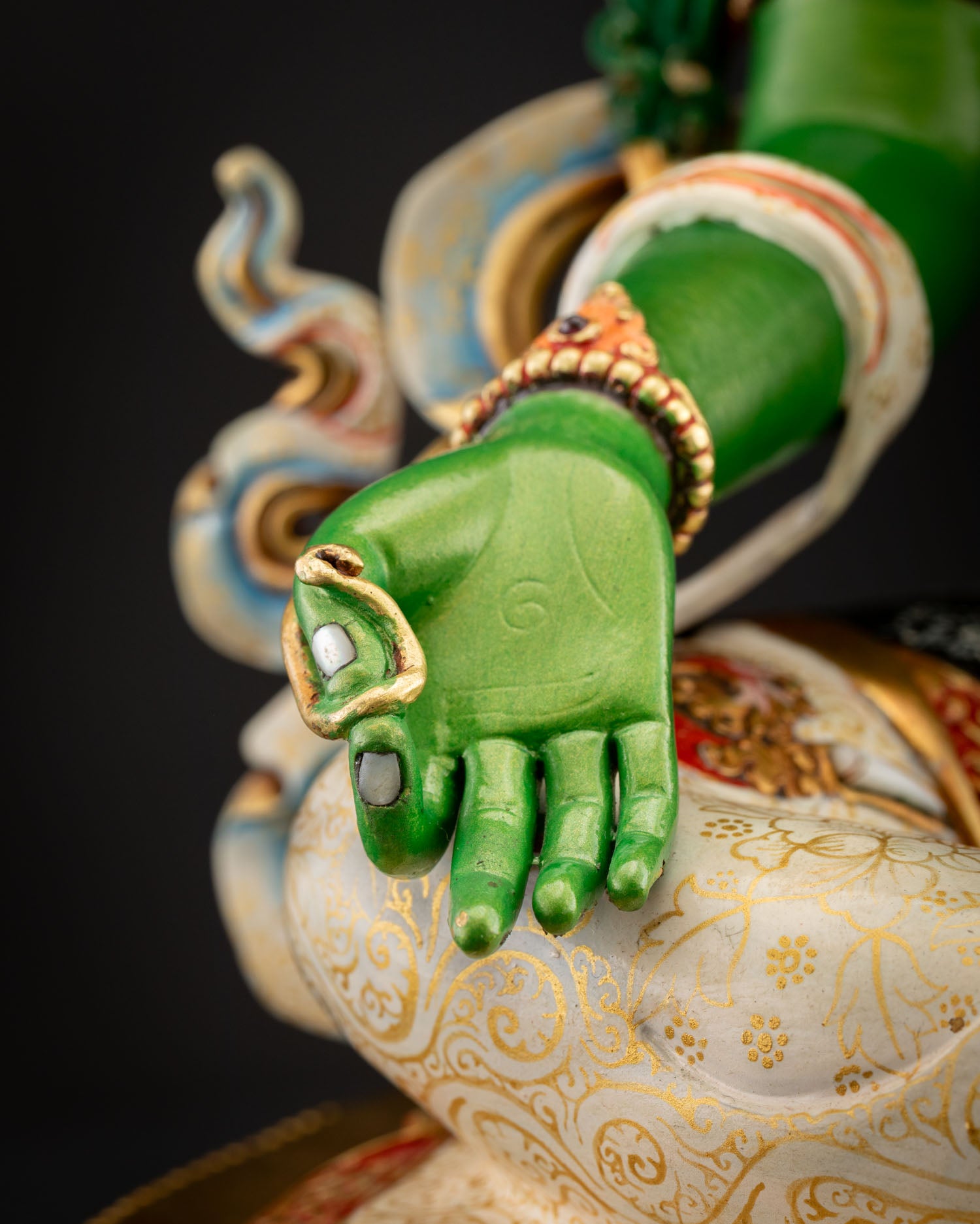 Close‑up of Green Tara right hand in Varada Mudra, palm extended downward symbolizing generosity