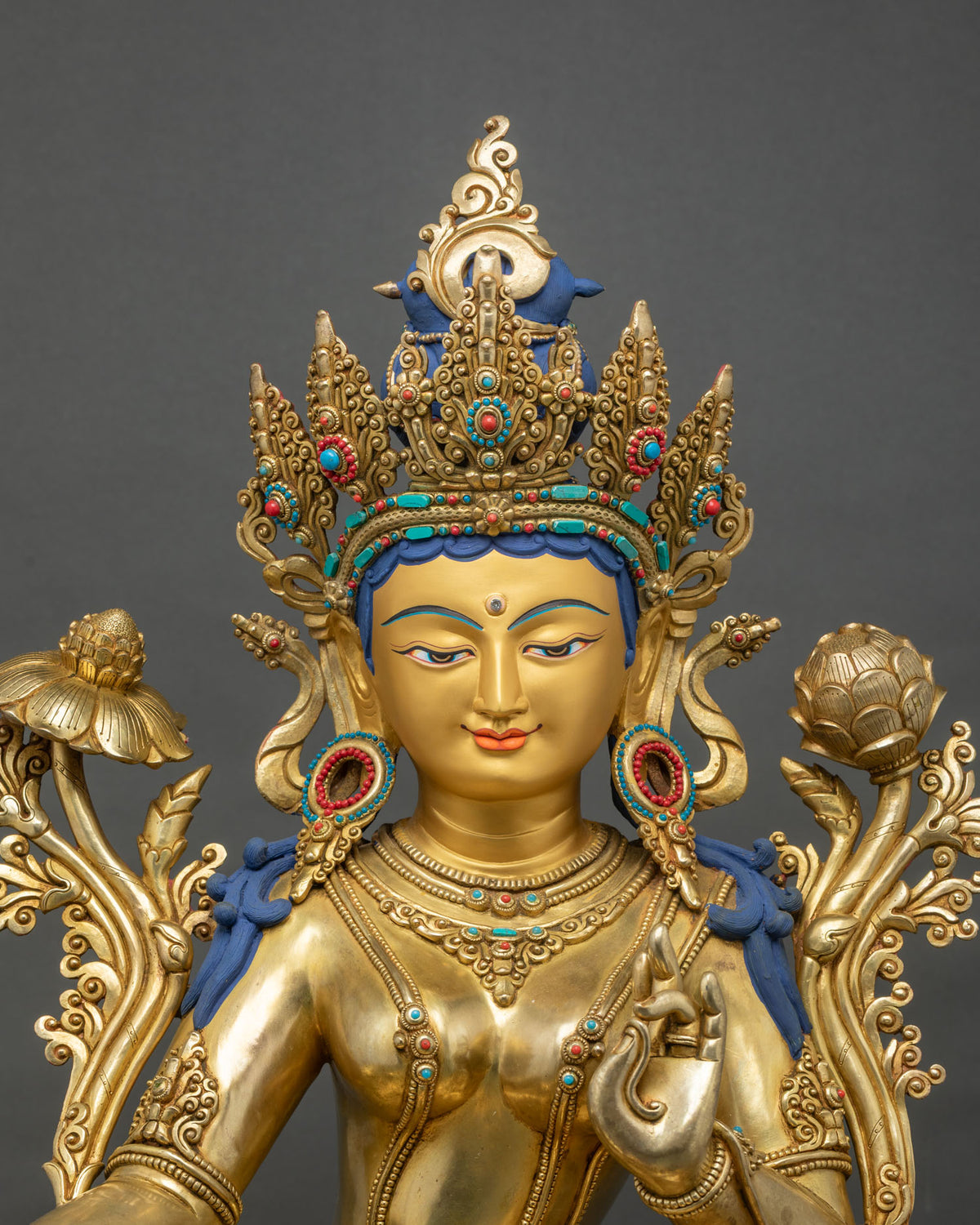 Close-up of Green Tara statue face and jeweled crown with turquoise and coral inlay
