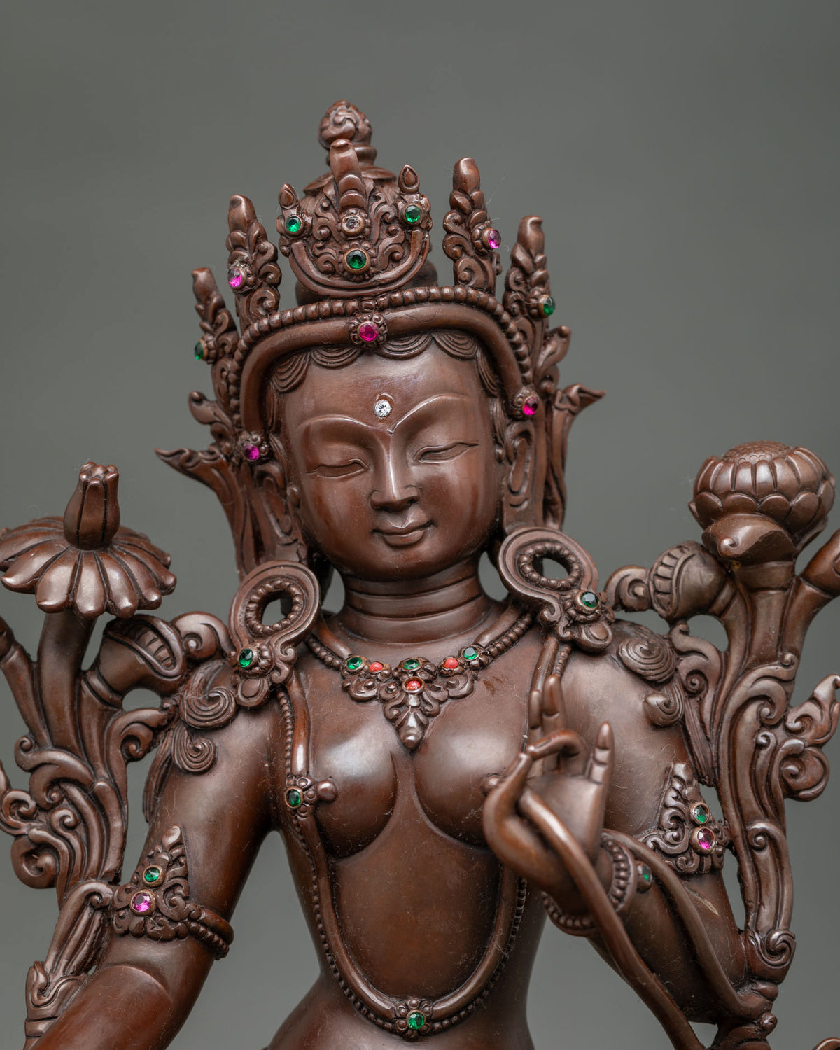Close up of Green Tara statue face crown and semi precious stones
