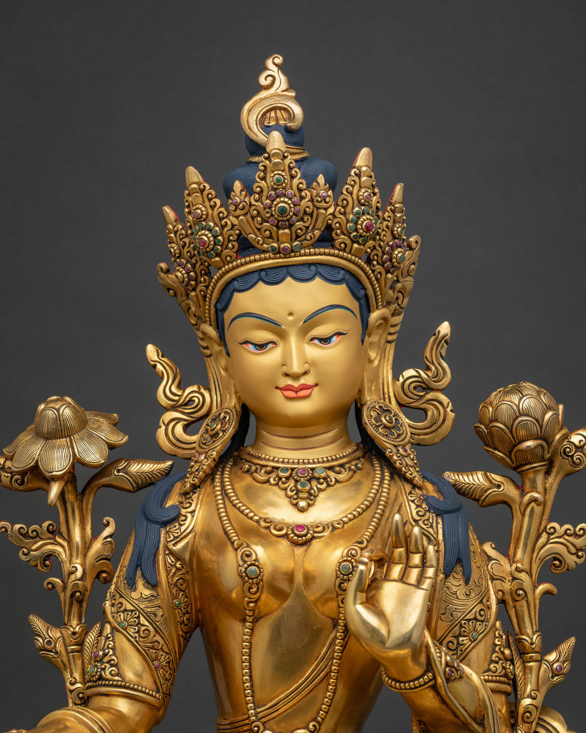 Close-up of Green Tara statue, gold-gilded copper sculpture with lotus flowers