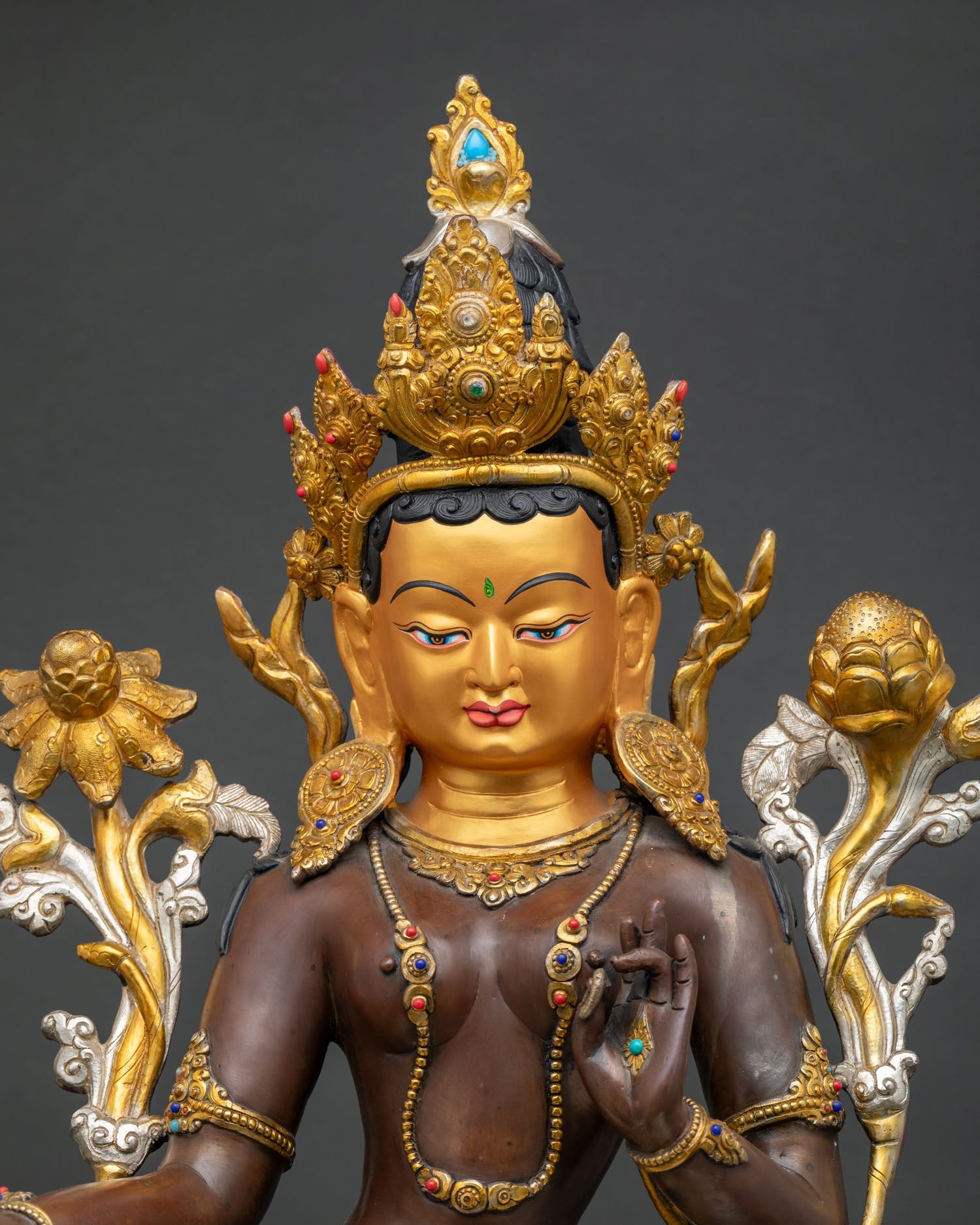 Close up of Green Tara statue highlighting copper craftsmanship and gold accents