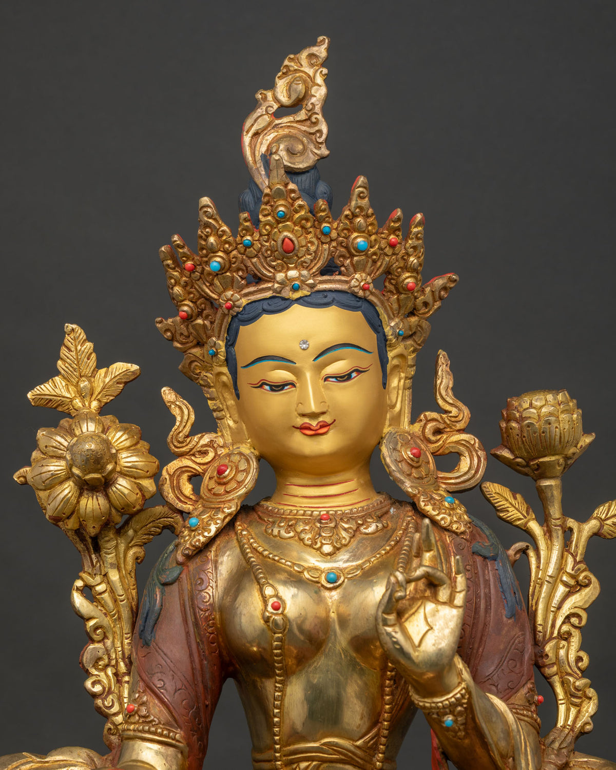 Close up of Green Tara statue with 24K gold painted face and detailed crown