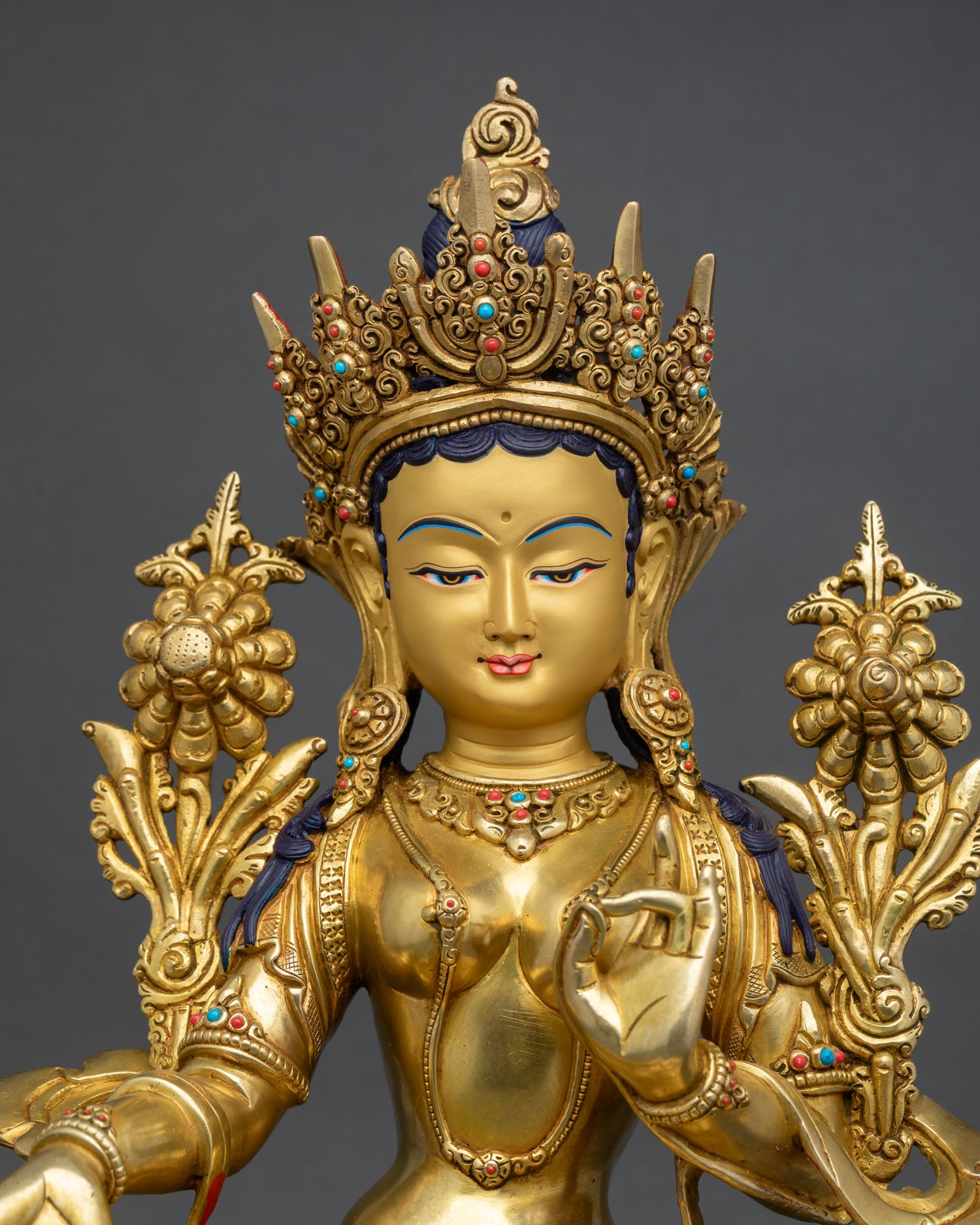 close-up of green tara statue with turquoise crown and gold gilded details