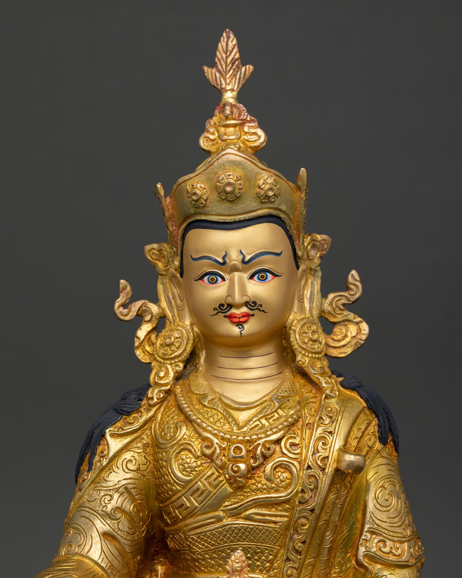 Close Up of Guru Padmasambhava Statue with Gold Painted Face and Intricate 3D Himalayan Carvings