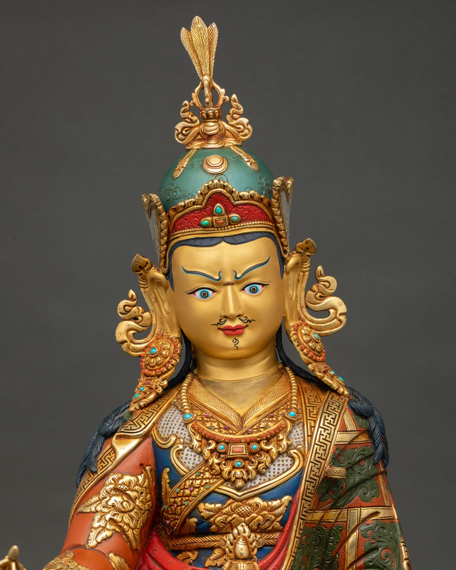 Close up of Guru Rinpoche Statue showcasing intricate gold gilded details and sacred ornaments