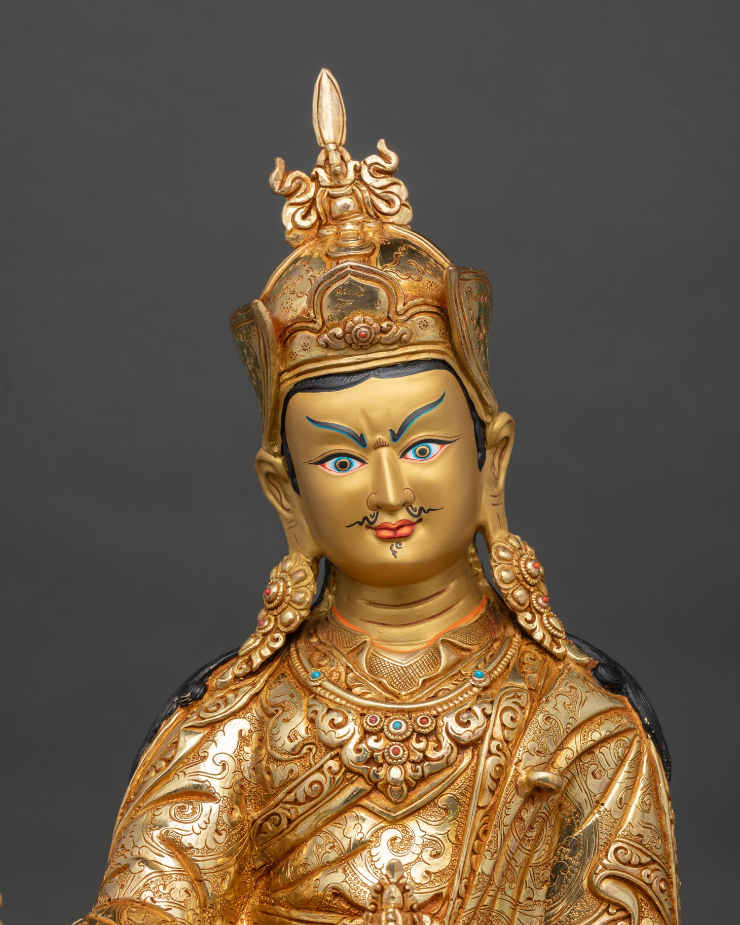 close up of guru rinpoche statue with 24k gold gilding and sacred details