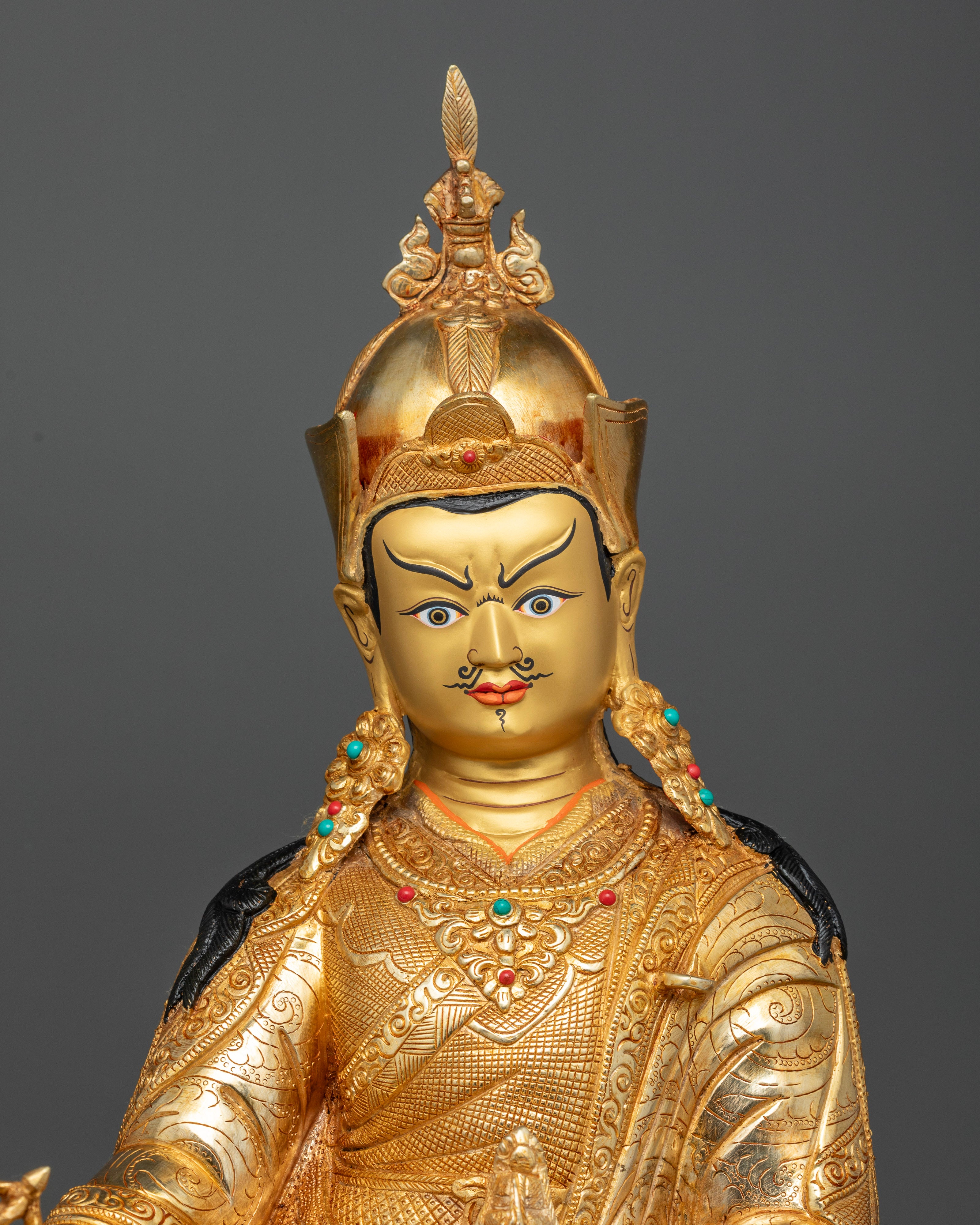 Close Up of Guru Rinpoche Statue with Gold Painted Face and Semi Precious Stones