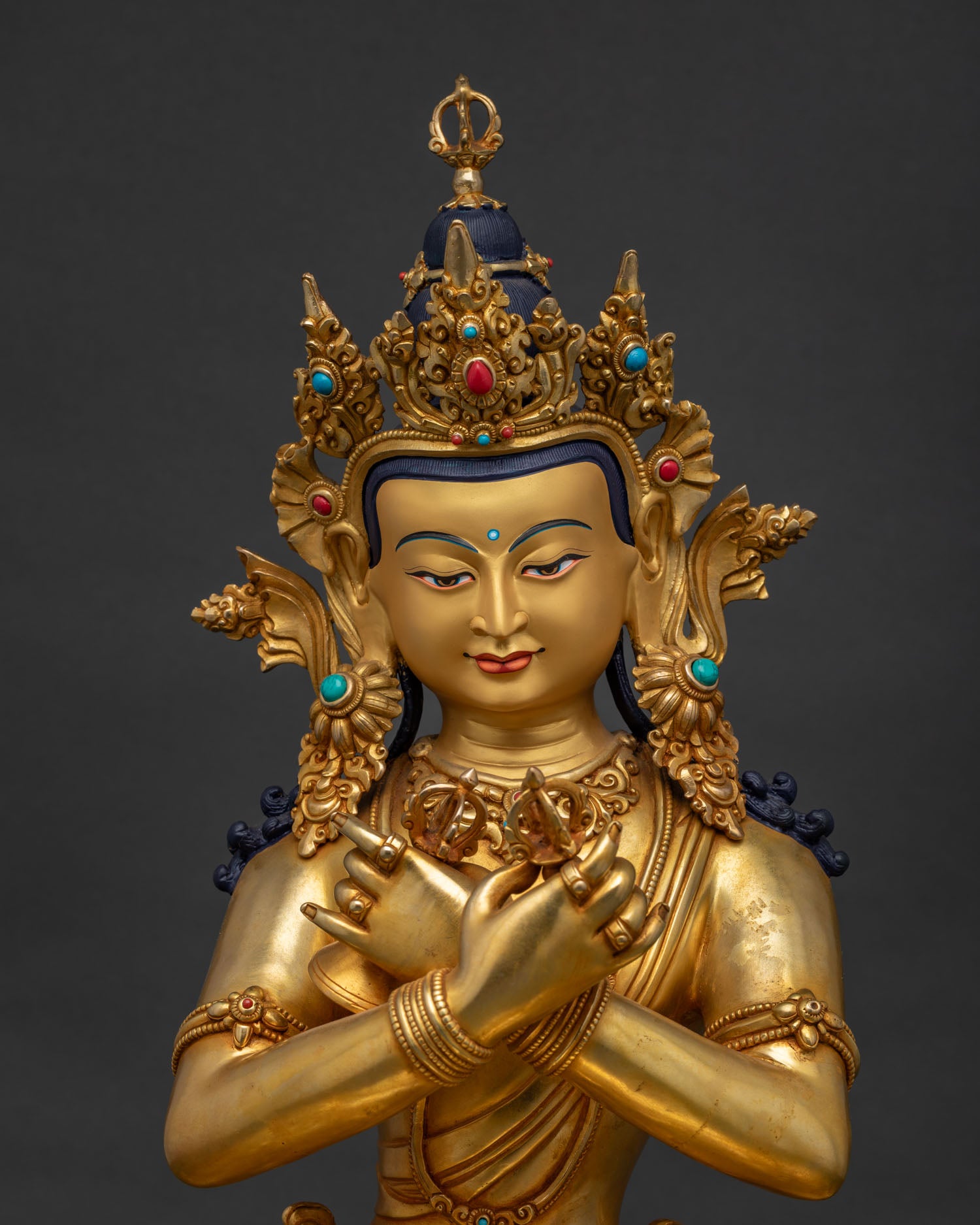 Close-up of hand-gilded Vajradhara statue showing intricate gold detailing and gemstone inlay