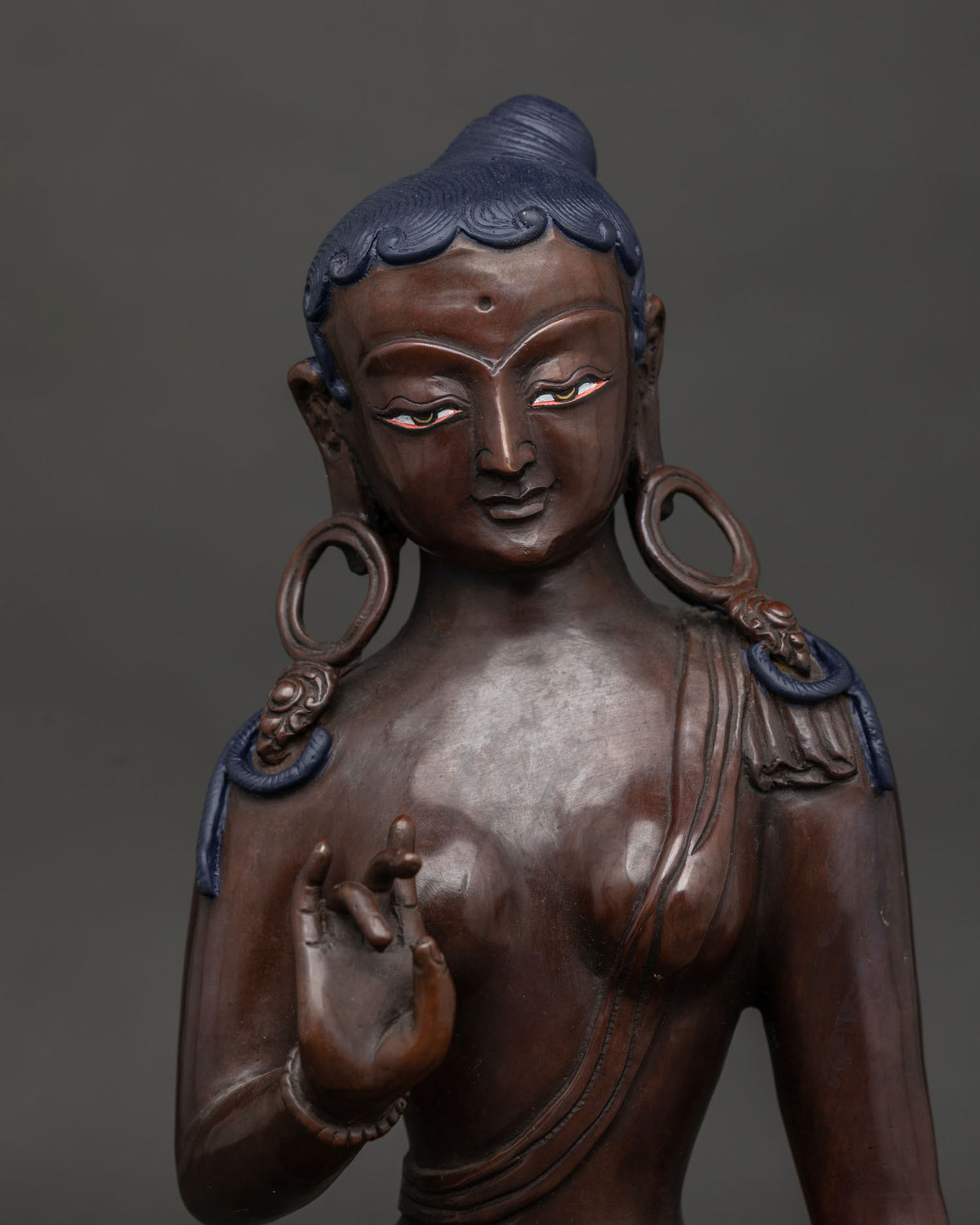 Close-up of handcrafted Green Tara copper statue from Nepal with oxidized finish and lotus seat