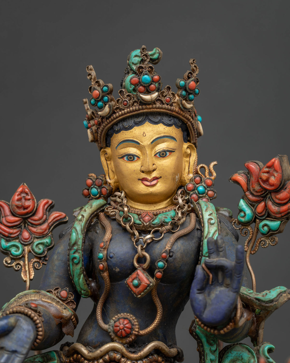 Close up of handcrafted Green Tara statue with coral, turquoise and silver filigree
