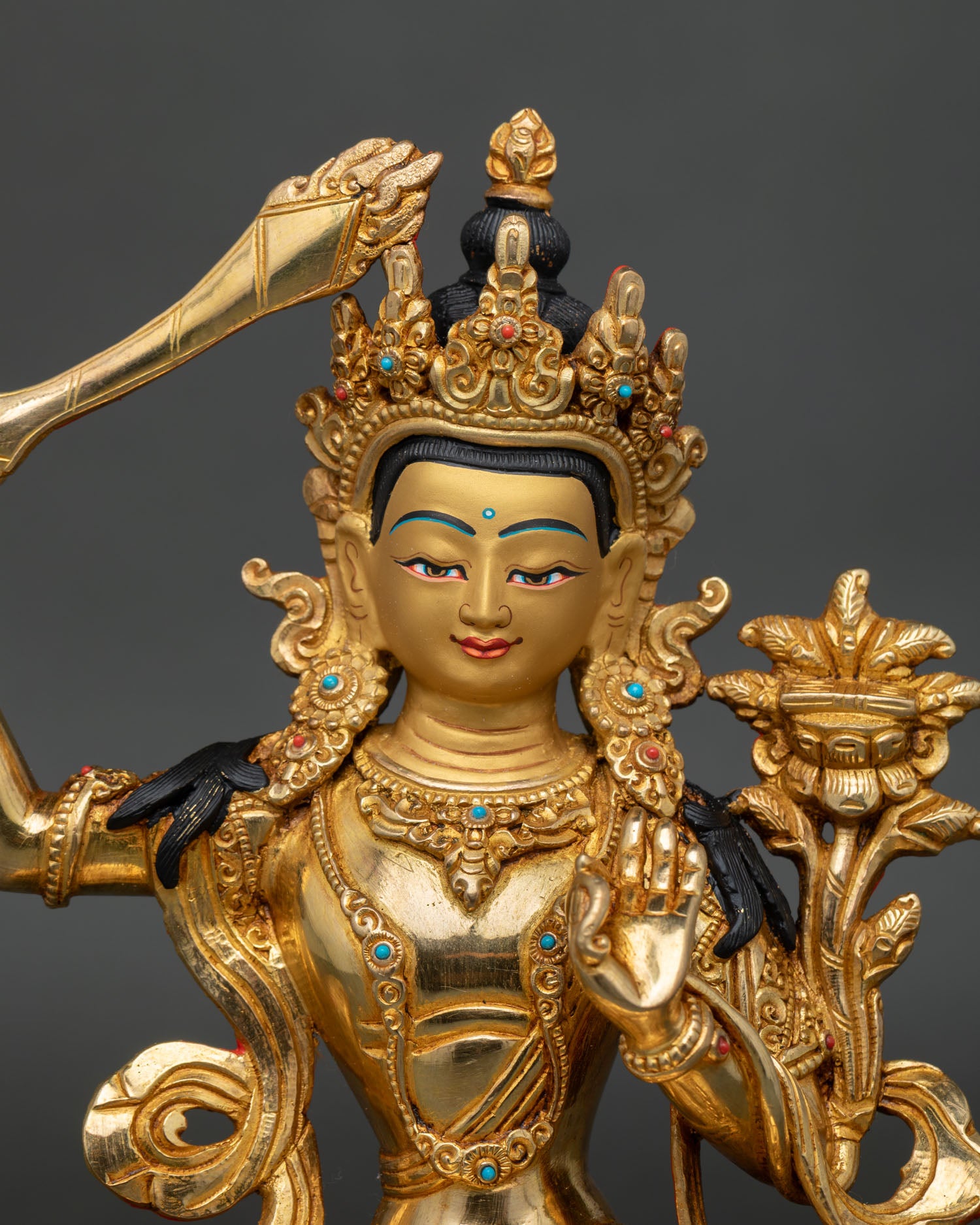 Close-up of handcrafted Manjushri Statue showcasing intricate gold-gilded details and sacred craftsmanship.