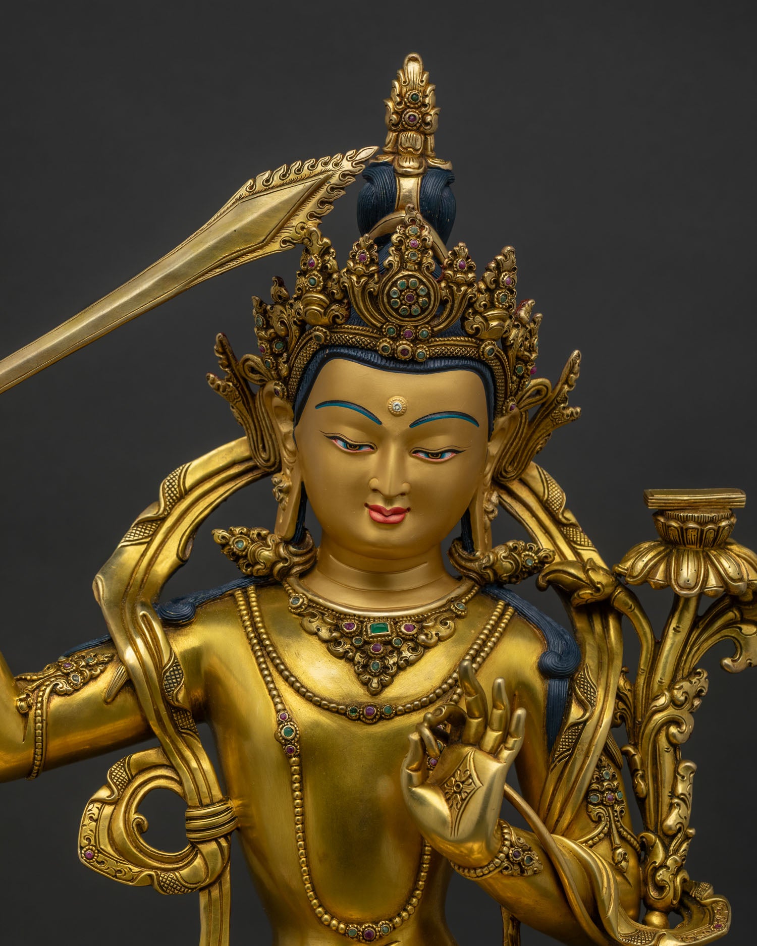 Close up of handcrafted Manjushri Statue with gold gilding and gemstone details