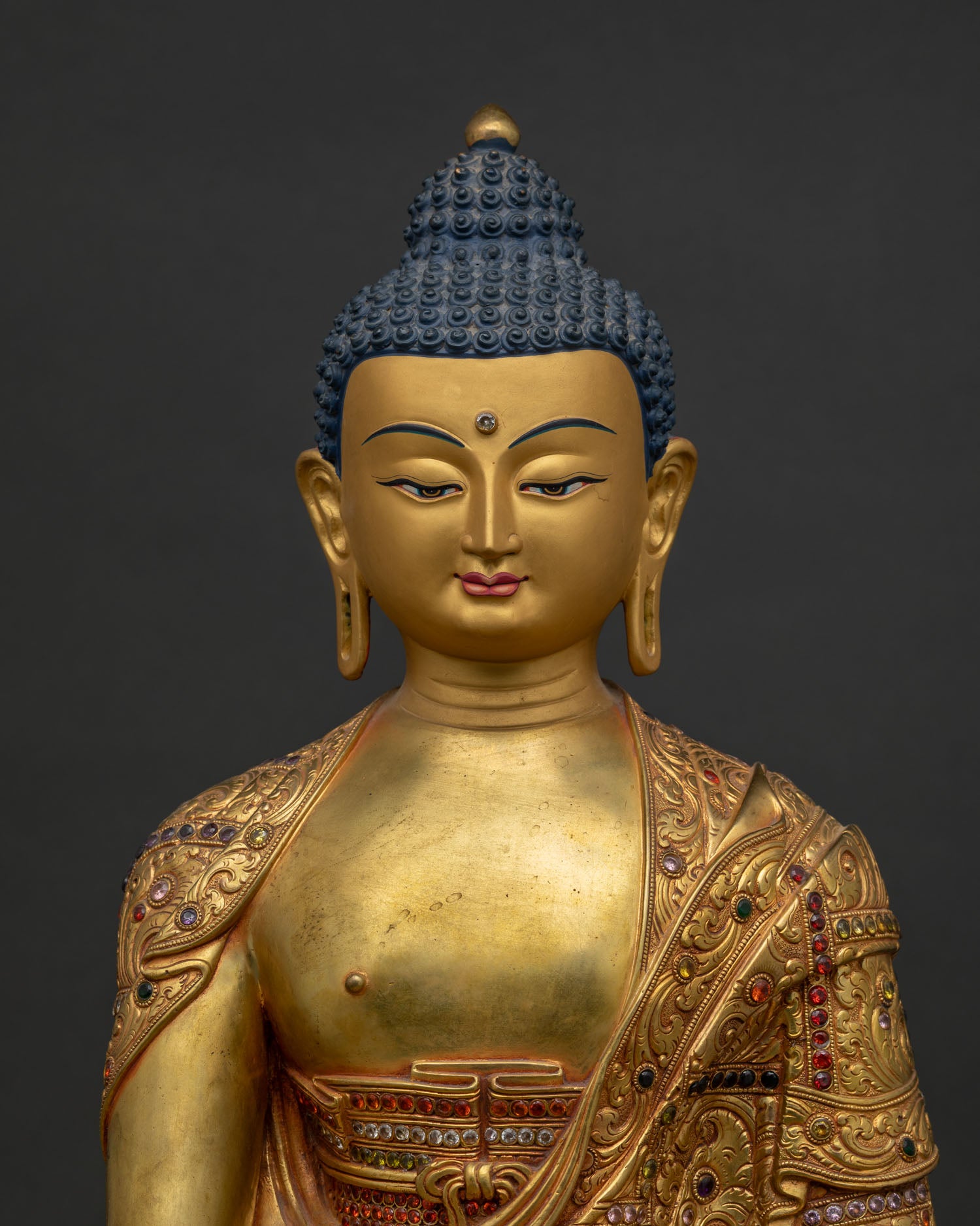 Close up of handcrafted Shakyamuni Buddha Statue with gold gilding and embossed copper details