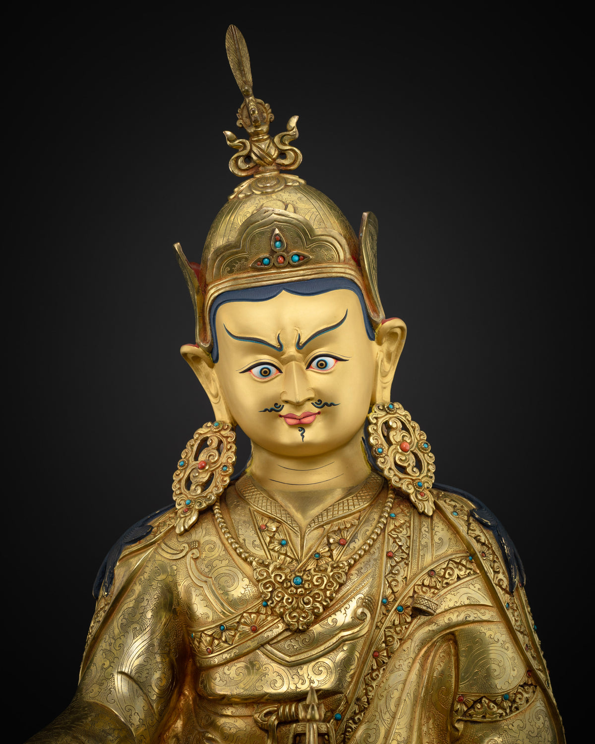 Close up of handmade Guru Rinpoche statue showing layered 24K gold fire-gilding on solid copper