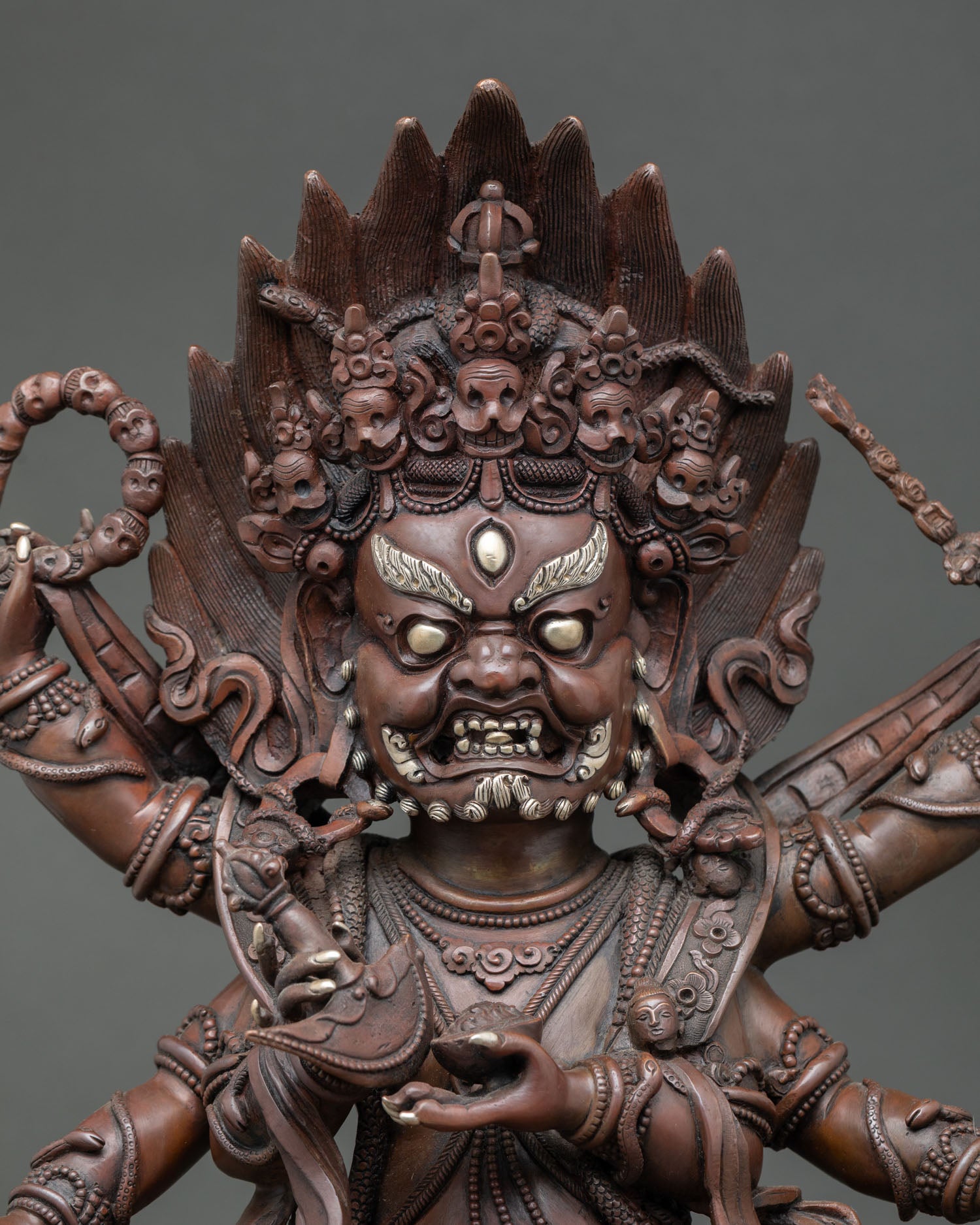 Close up of handmade Six Arm Mahakala Statue with oxidized copper and sacred ornaments