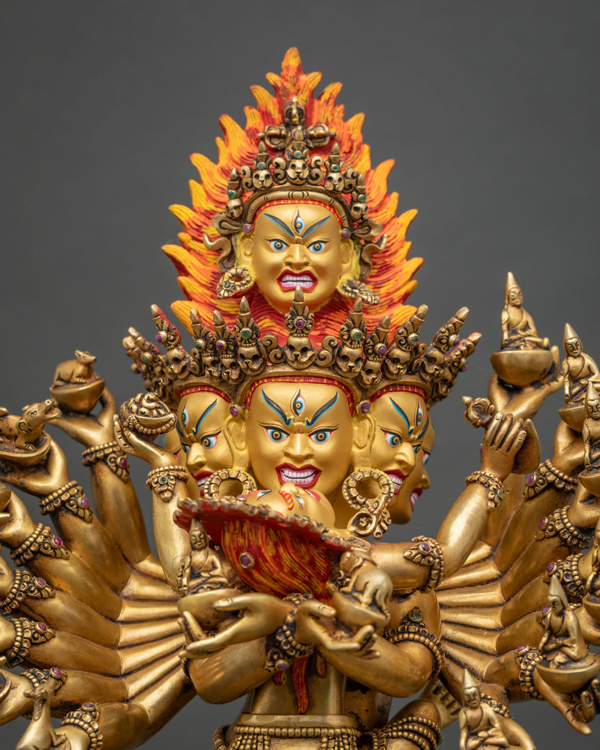 Close-up of Hevajra’s wrathful faces, five-skull crown and flaming top head, 24K fire-gilded copper