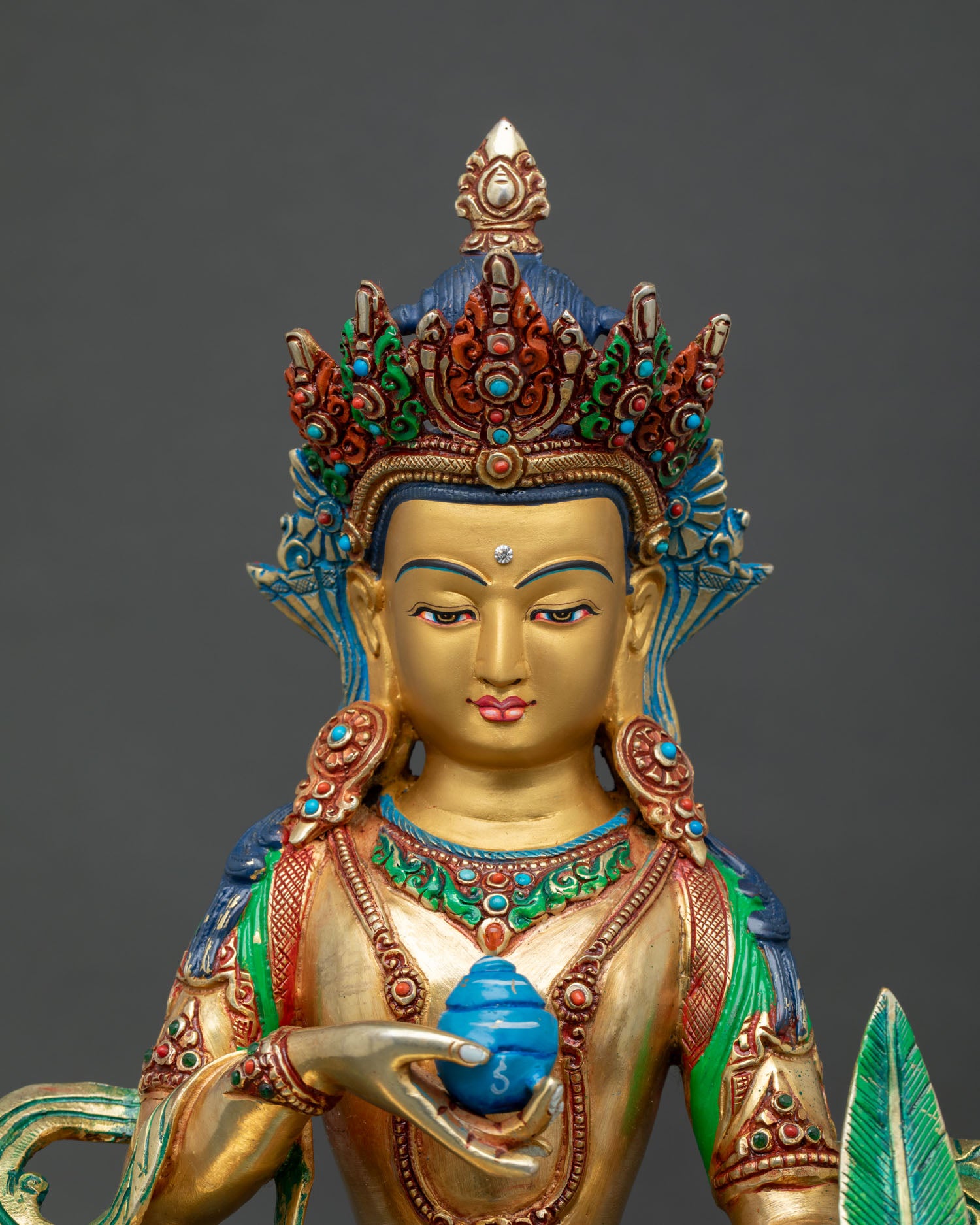 Close up of Kshitigarbha Buddhist statue showing hand painted details and sacred ornaments