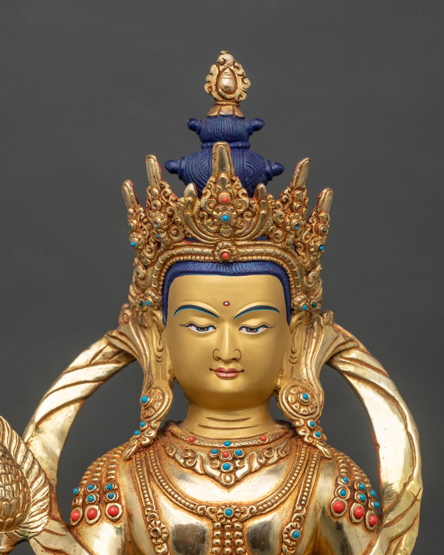Close-up of Kshitigarbha hands holding sacred Cintamani jewel and semi-precious stones