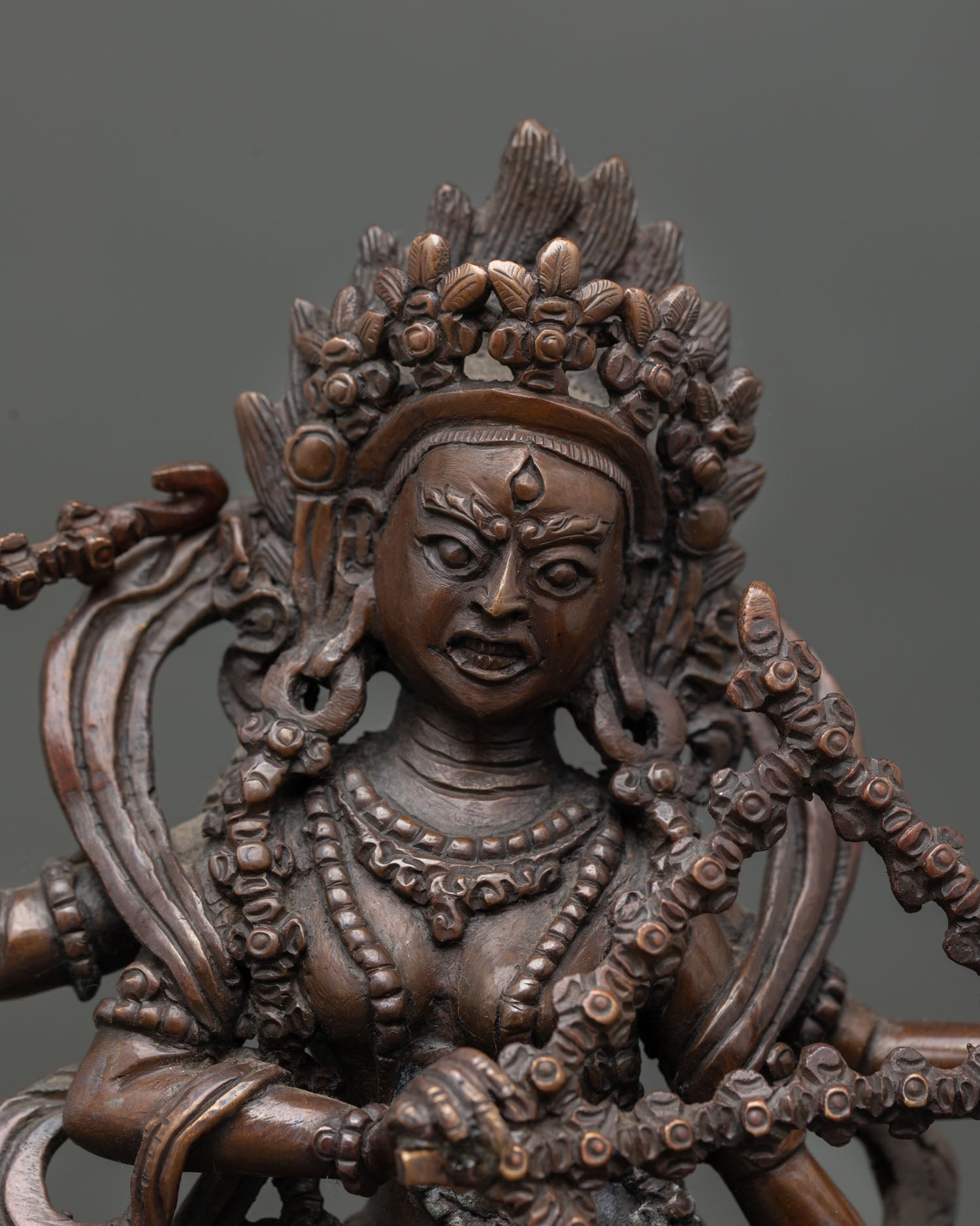 Close up view of Kurukulla statue showing four arms holding hook noose bow and flower arrows with intricate detailing
