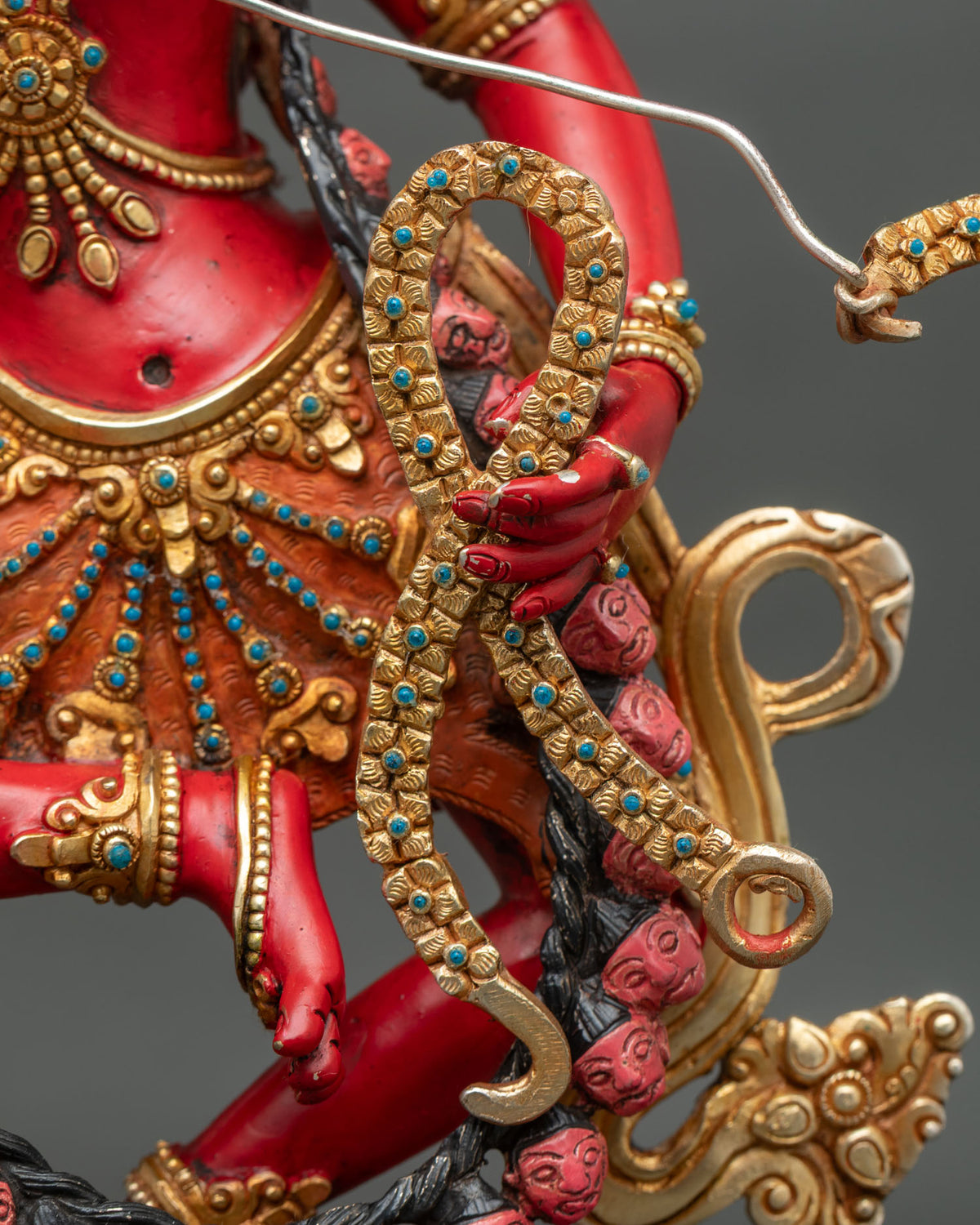 Close-up of Kurukulla statue torso with gold ornaments, turquoise inlay and flower bow in hand