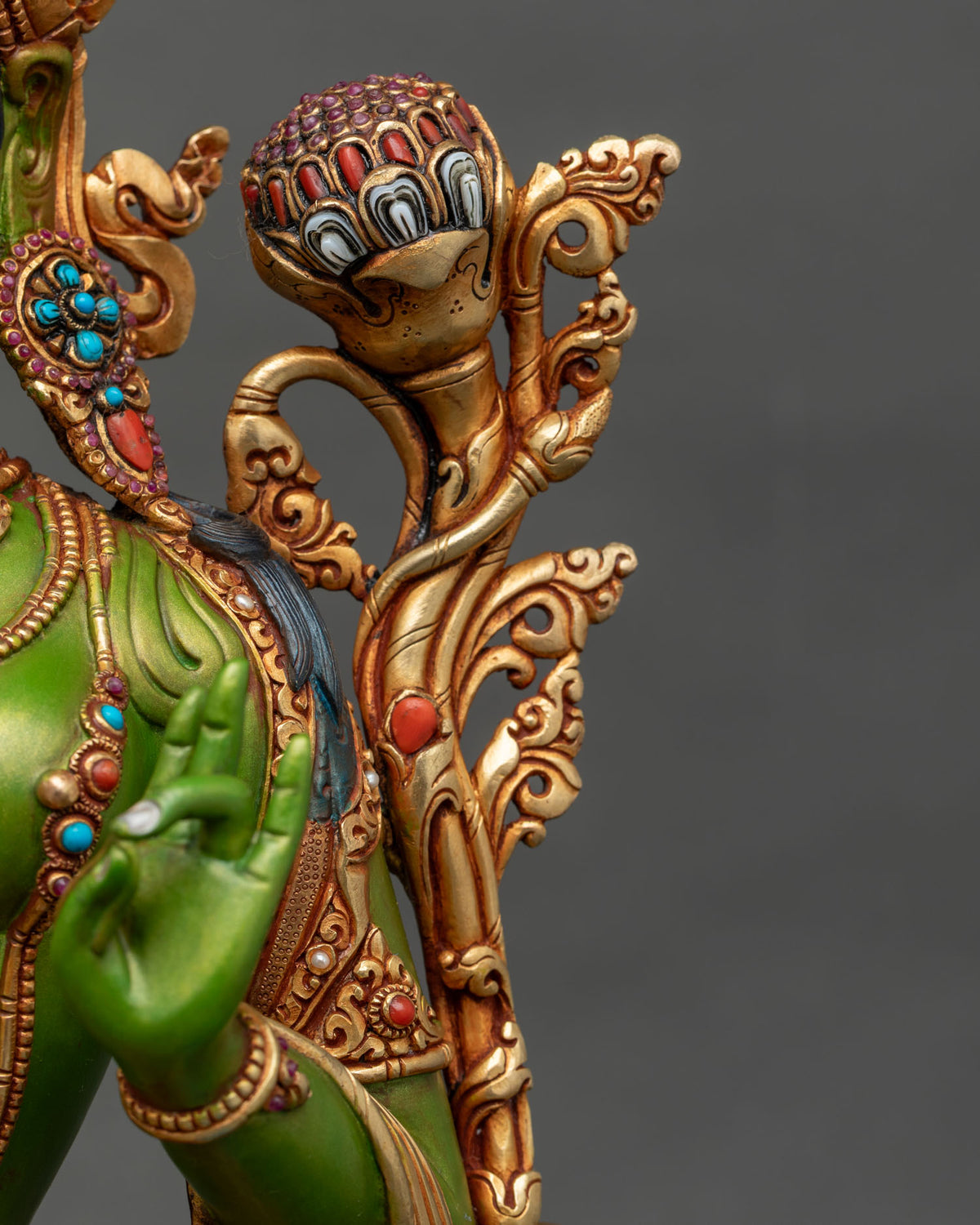 Close-up of lotus bud on gilded stem with coral and white inlays, Green Tara statue