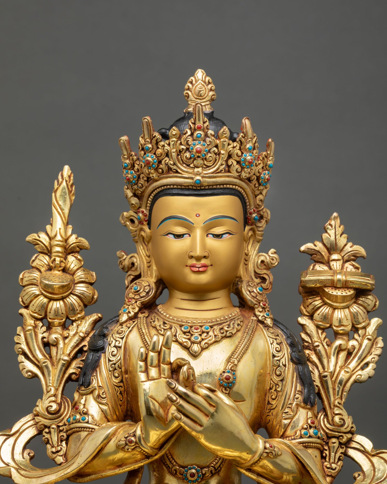 Close up of Manjushree Statue with gold painted face semi precious stones and wisdom expression