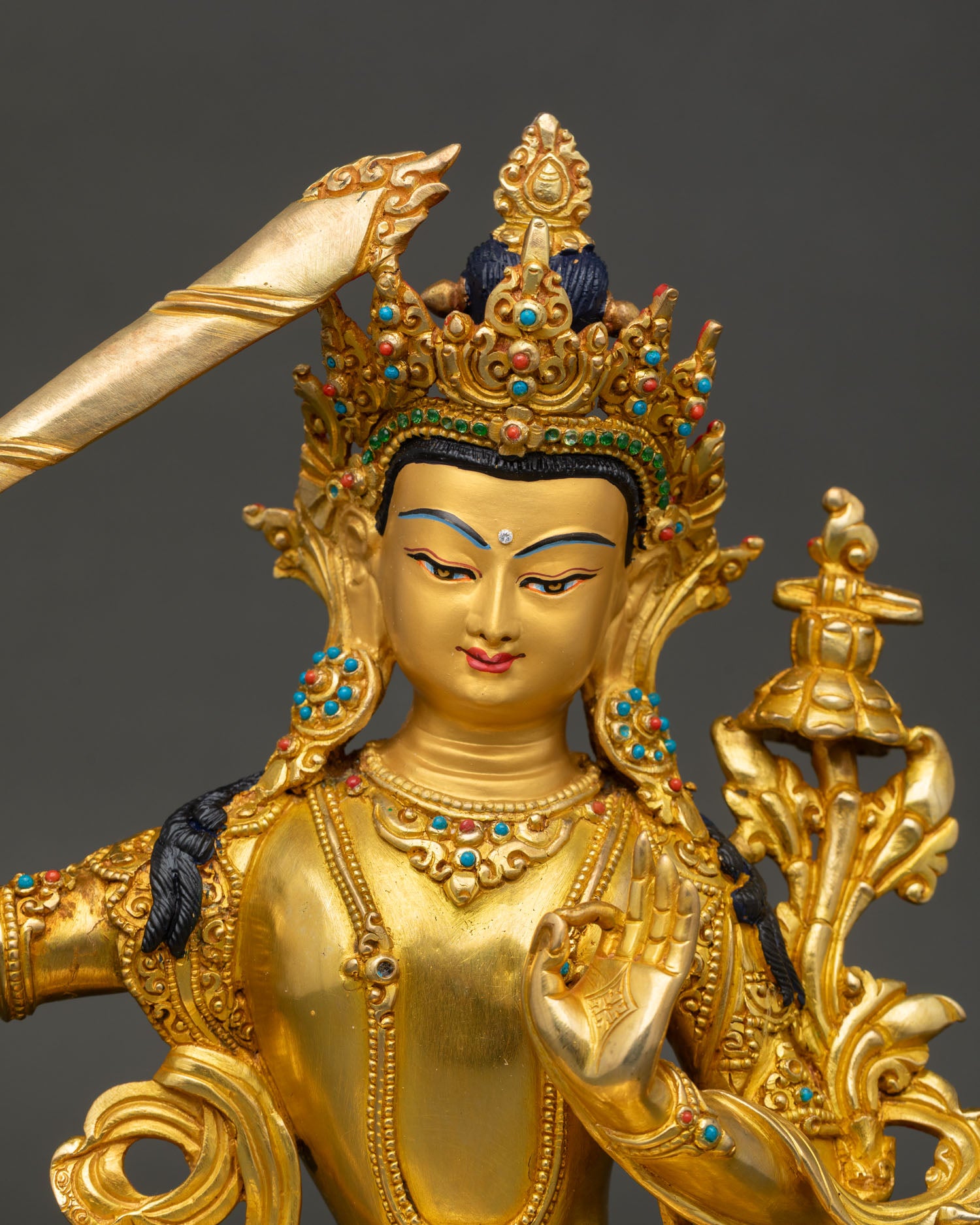 close up of manjushri bodhisattva statue showing intricate crown and gilded details