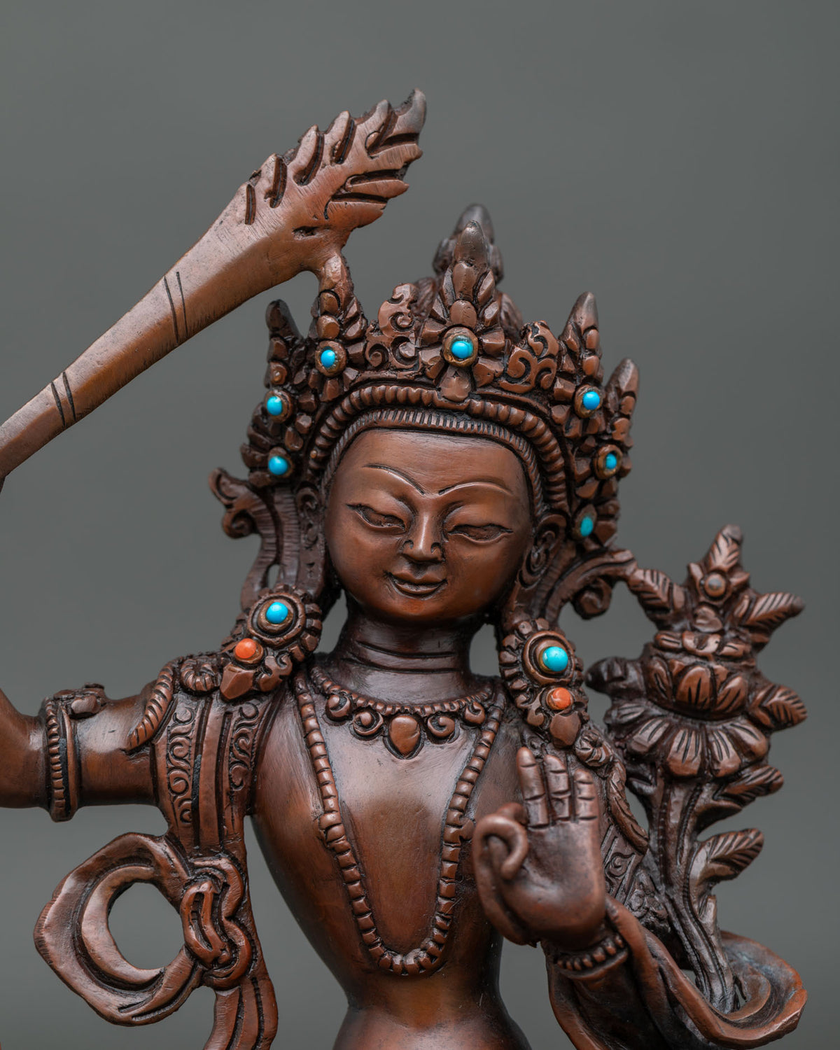 Close up of manjushri face wisdom sword lotus flower and copper details.