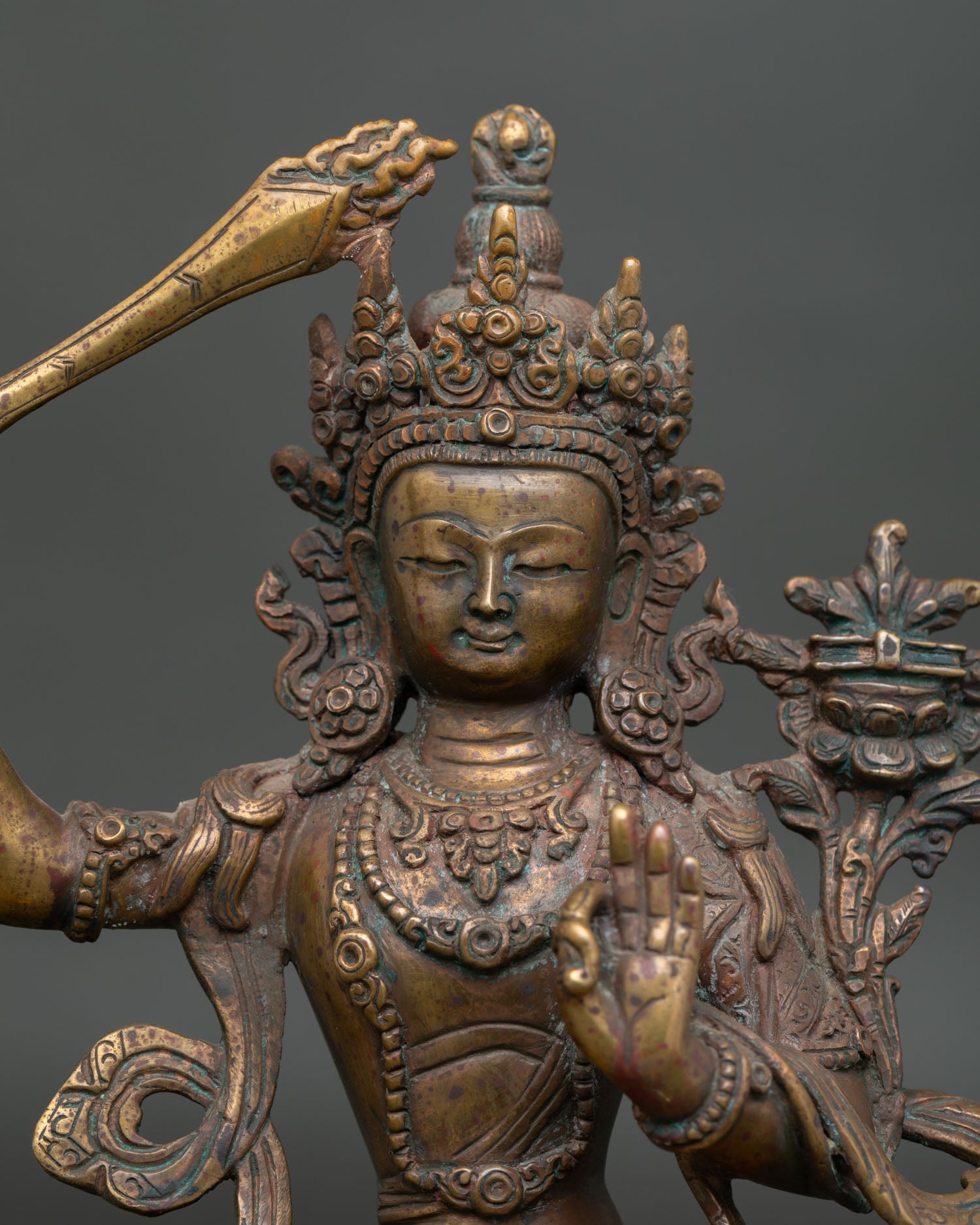 close up of manjushri statue face with serene expression and intricate buddhist details