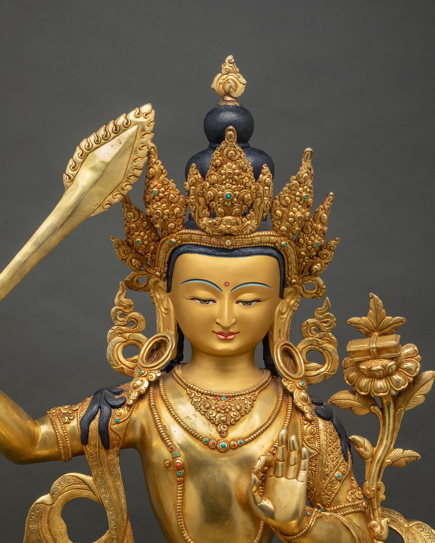 Close up of Manjushri statue showing gold gilded crown and jewelry, Nepal