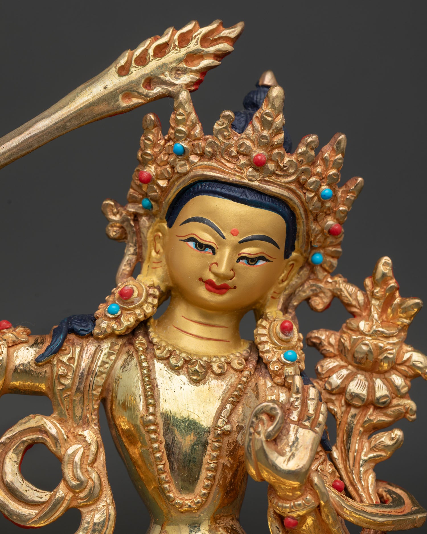 Close Up of Manjushri Statue with Wisdom Sword, Gold Painted Face and Semi Precious Stones