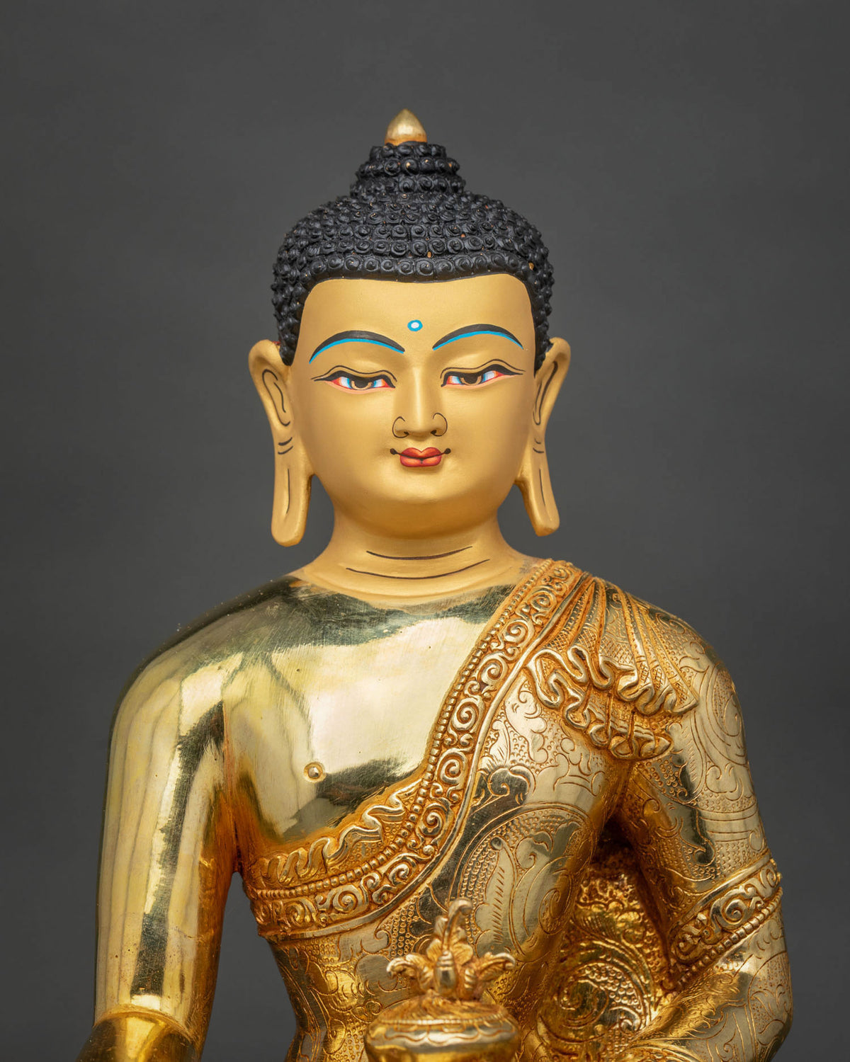 Close-up of Medicine Buddha Statue highlighting the gold-painted face, intricate robe details, and traditional Newari craftsmanship.