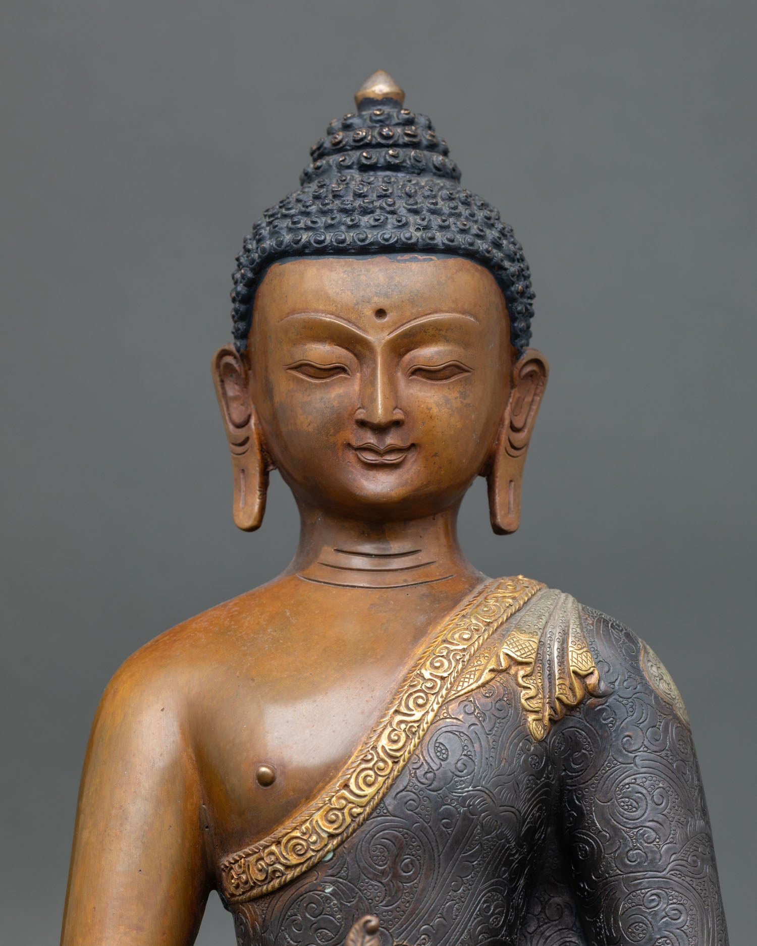 close up of medicine buddha statue with silver-plated lotus and healing bowl