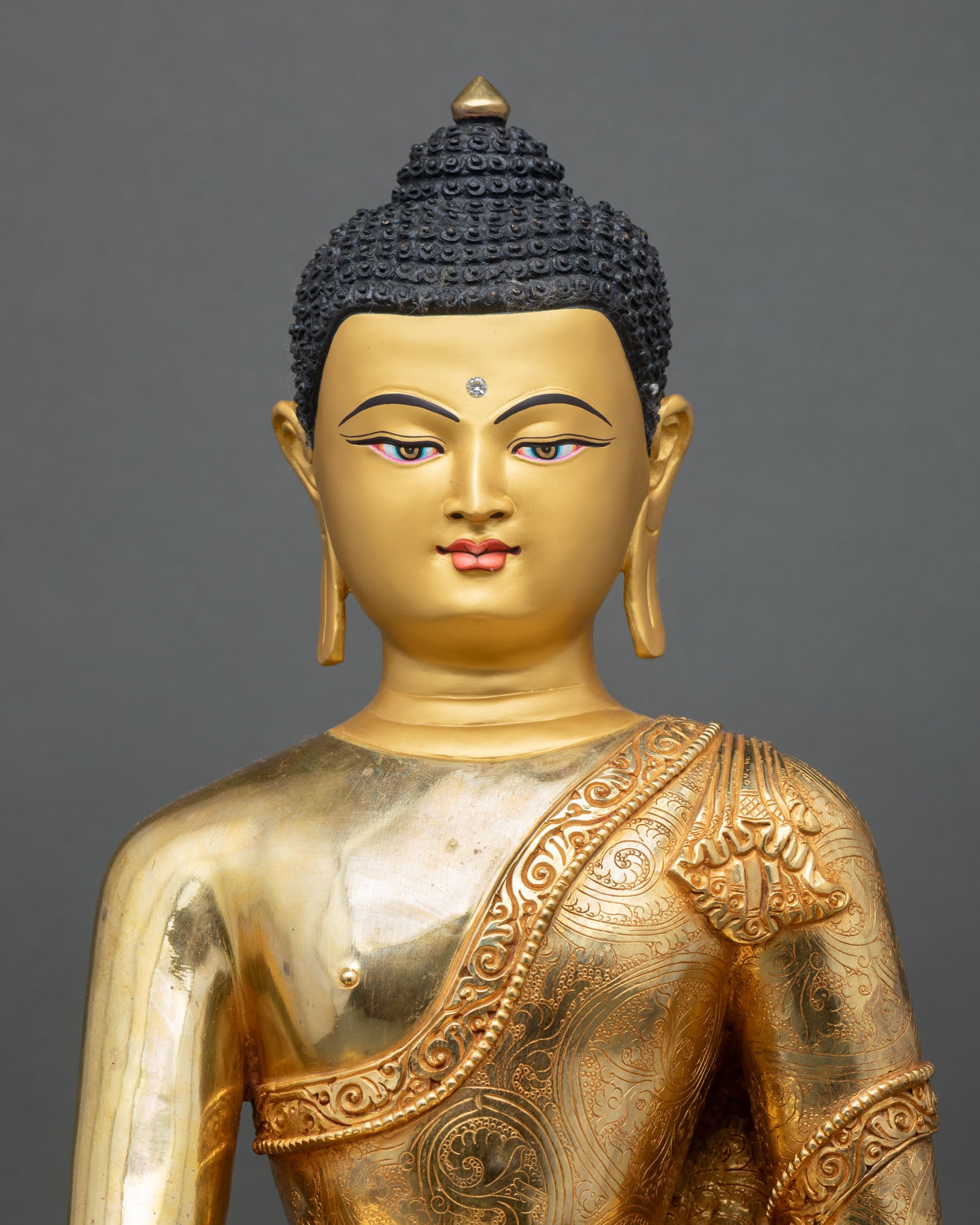 close up of meditating Shakyamuni Buddha statue with gold-gilded copper details