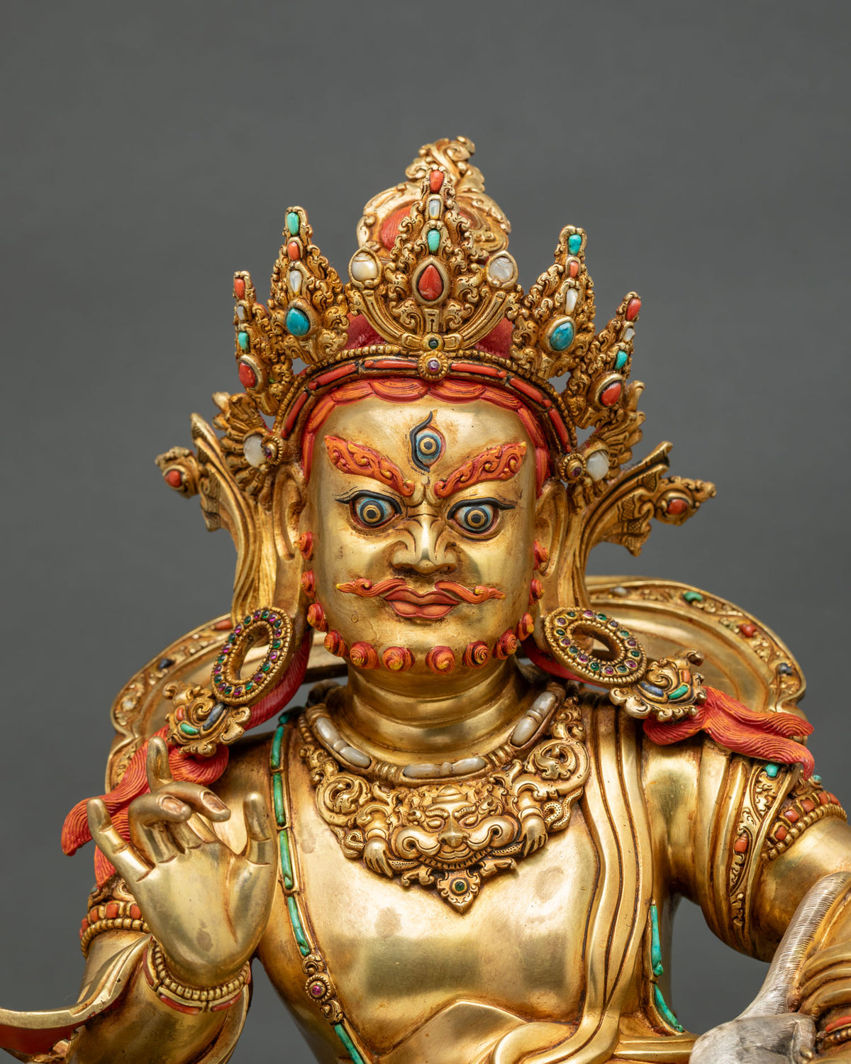 Close-up of Namtoshe statue face with jeweled crown, turquoise and coral inlay, and gold fire-gilding